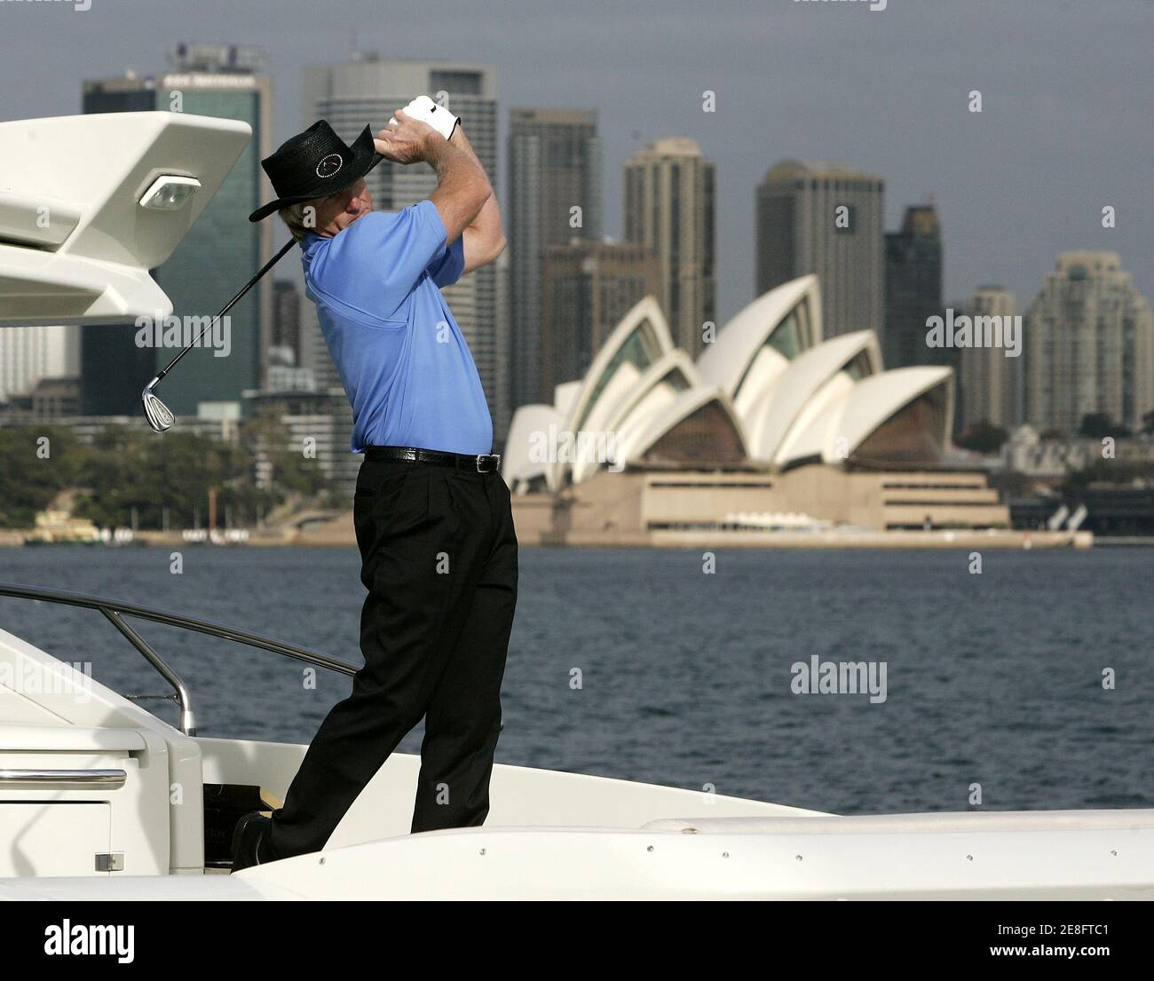 Australian golfer Greg Norman follows through during his swing from the back of a luxury yacht on Sydney Harbour May 11, 2006. Norman was promoting the Australian Open golf championship which is scheduled to be held in Sydney November 13-19. REUTERS/Will Burgess Stock Photo