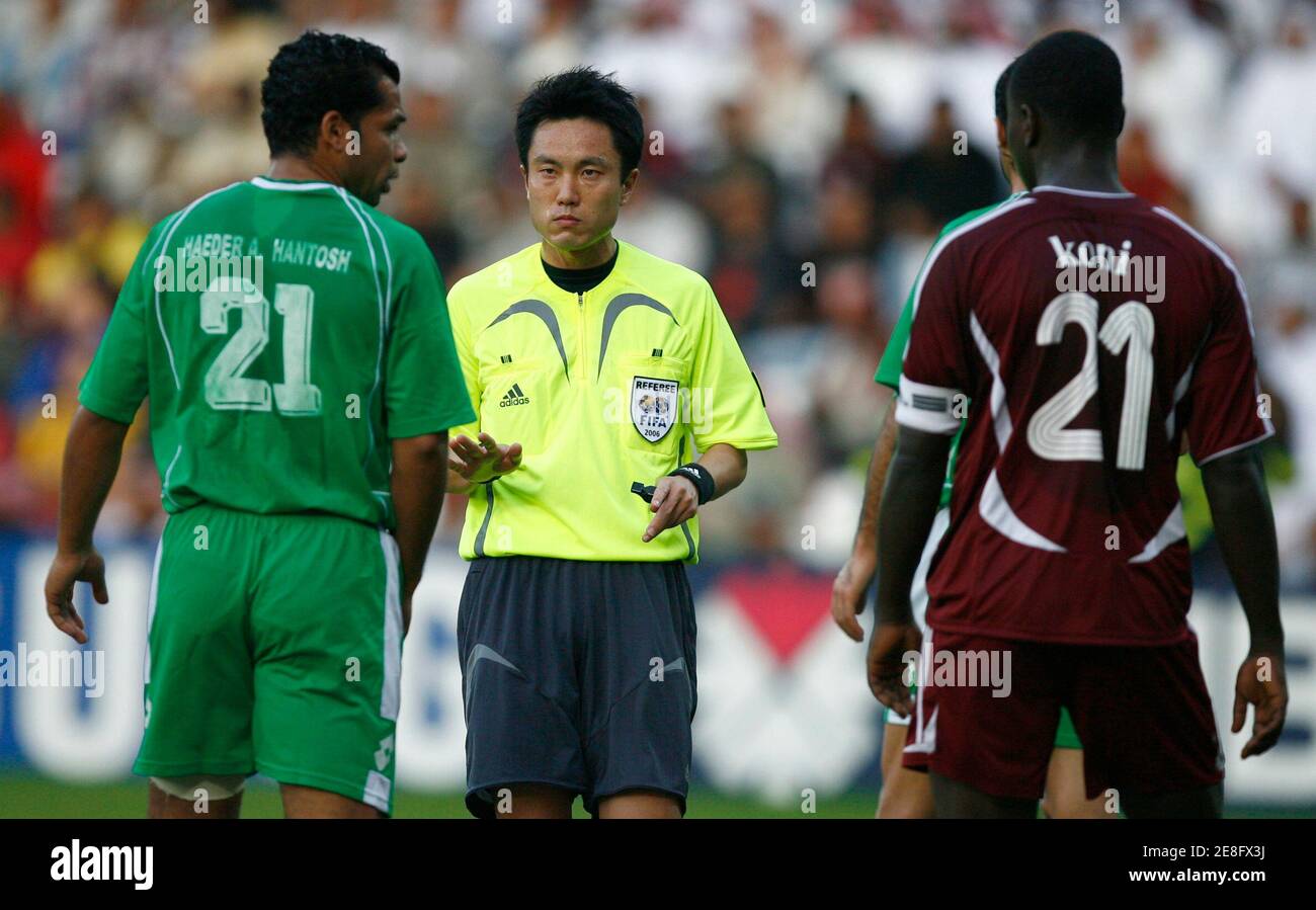 Referee Hiroyoshi Takayama (C) of Japan cautions Iraq's Haeder Hantosh (L) and Qatar's Abdulla Obaid Koni (R) during the men's gold medal soccer match at the 15th Asian Games in Doha December 15, 2006.     REUTERS/Jerry Lampen    (QATAR) Stock Photo