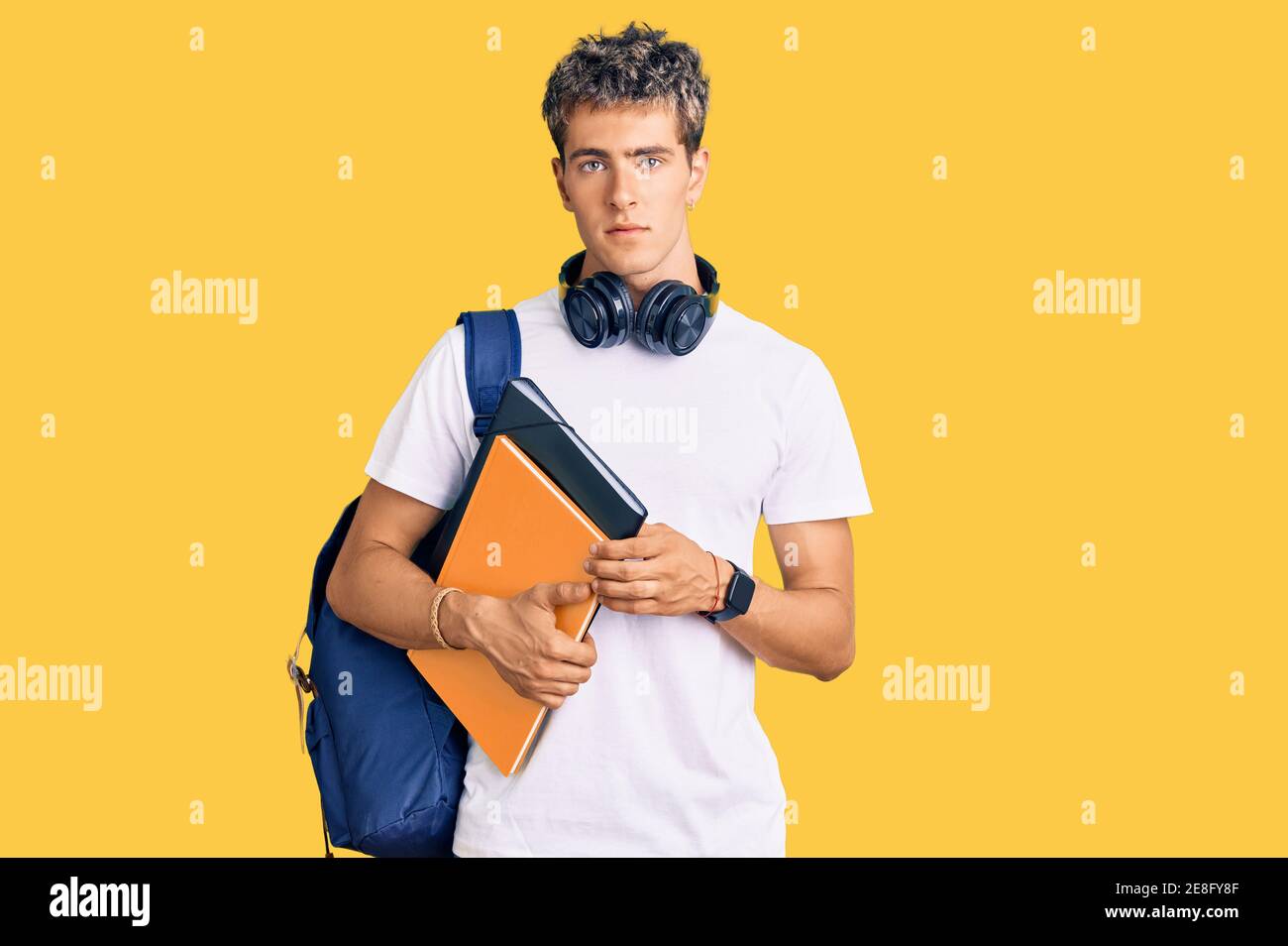 Young handsome man holding student backpack and books thinking attitude ...