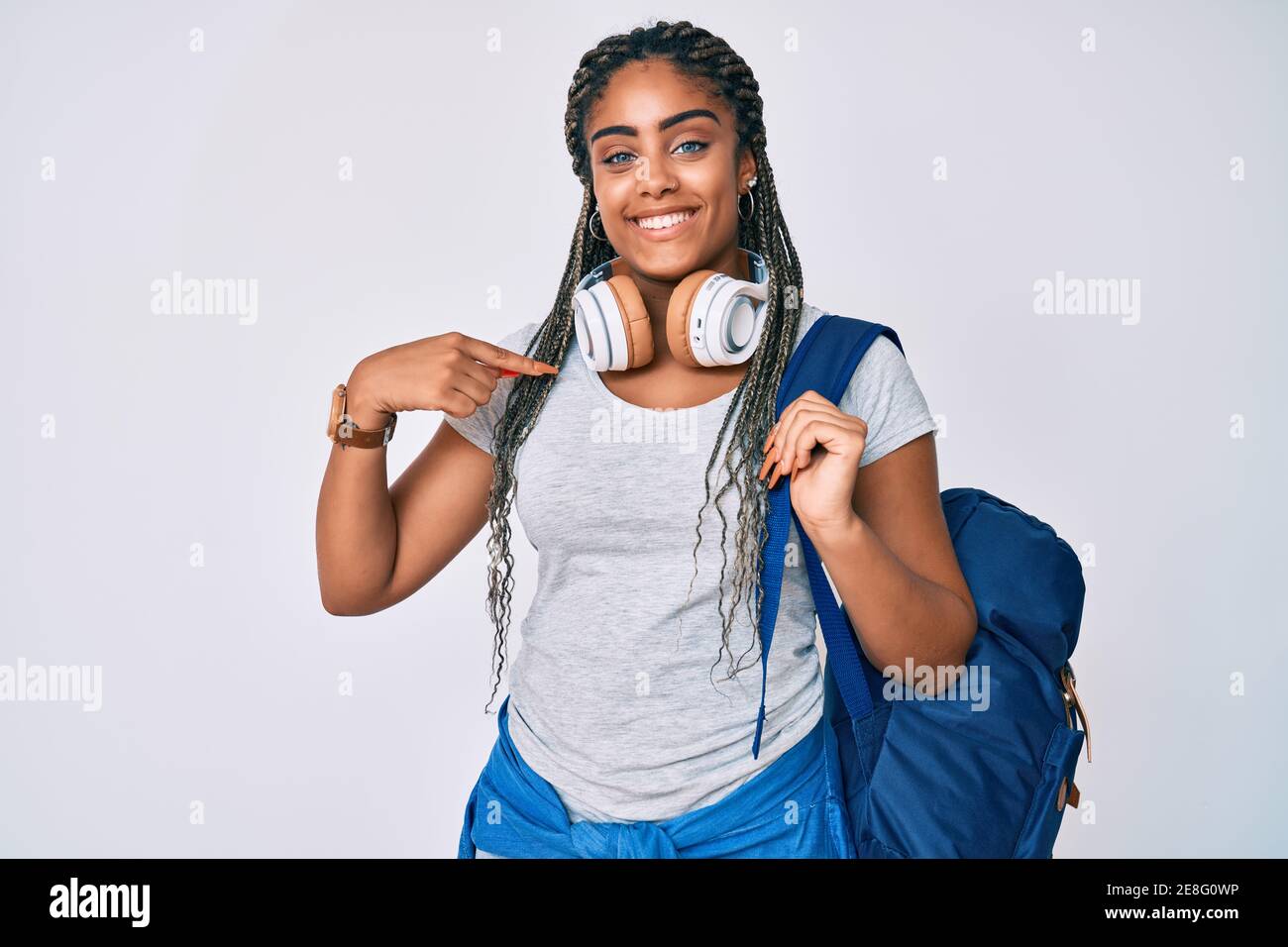 Young african american woman with braids wearing student backpack and
