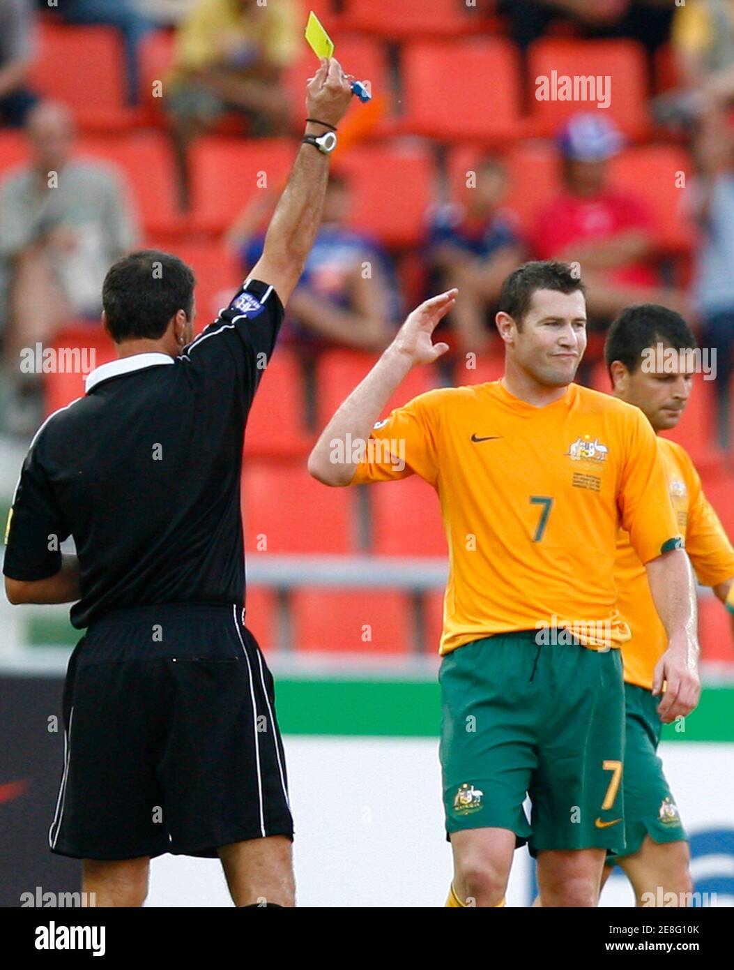 Australia's Brett Emerton reacts after receiving a yellow card from referee Eddy Maillet during Australia's Group A soccer match against Oman at the AFC Asian Cup at Rajamangala Stadium in Bangkok July 8, 2007. Walking past Emerton is team mate Mile Sterjovski.   REUTERS/Jerry Lampen   (THAILAND) Stock Photo