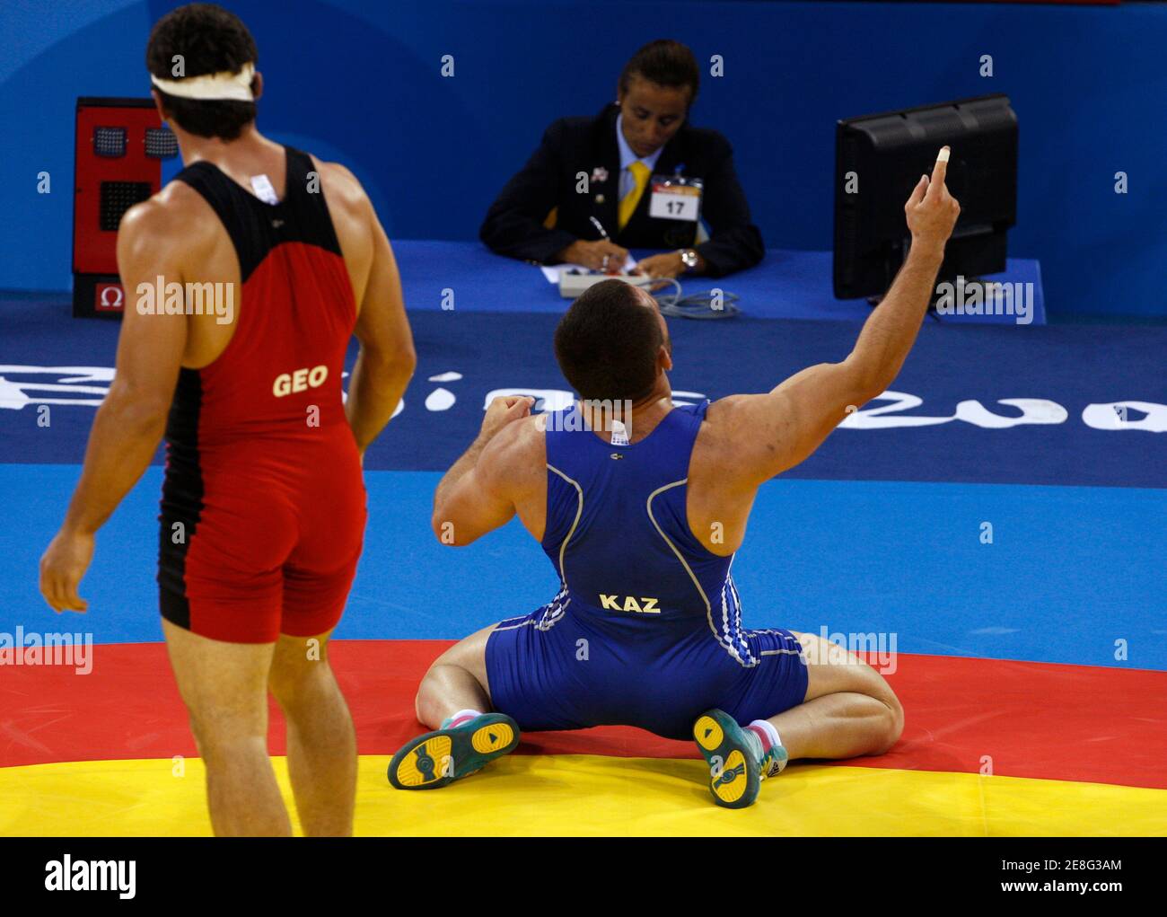 Taimuraz Tigiyev of Kazakhstan (in blue) celebrates his victory against George Gogshelidze of Georgia at the end of their 96kg men's freestyle wrestling semi-final match at the Beijing 2008 Olympic Games August 21, 2008. REUTERS/Oleg Popov (CHINA) Stock Photo