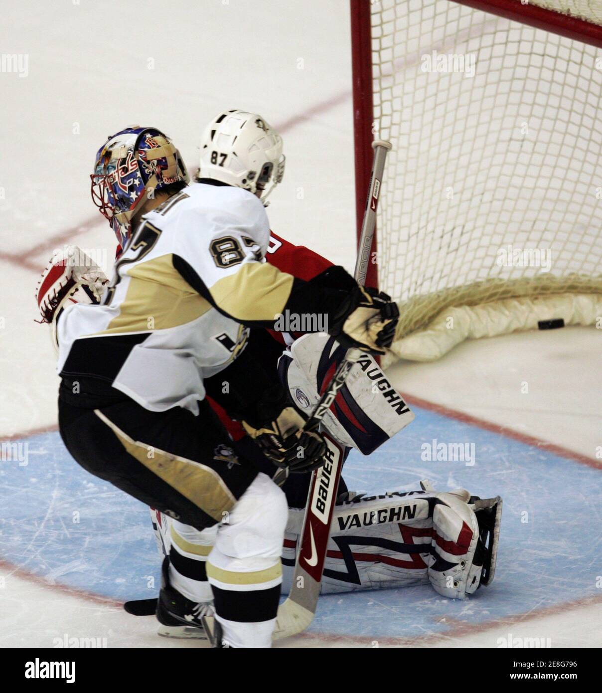 Pittsburgh Penguins' Sidney Crosby (front) scores on Washington Capitals goaltender Jose Theodore in the shootout of their NHL hockey game in Washington, March 8, 2009. The Penguins won the game, 4-3, in the shootout.   REUTERS/Gary Cameron    (UNITED STATES) Stock Photo