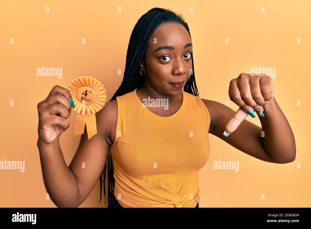 Young african american woman holding fourth place badge with angry face, negative sign showing dislike with thumbs down, rejection concept Stock Photo