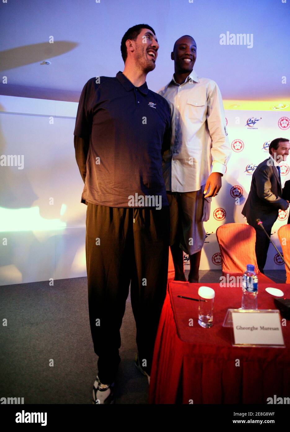 Washington Wizards player Caron Butler (R) stands on a chair while posing with former Bullets player Gheorghe Muresan of Romania during a news conference in Beijing September 8, 2009. The Wizards are commemorating the 30th anniversary of the team's 1979 trip to China with a 10-day, five-city goodwill tour. The Wizards were previously known as the Washington Bullets.  REUTERS/Jason Lee (CHINA SPORT BASKETBALL) Stock Photo