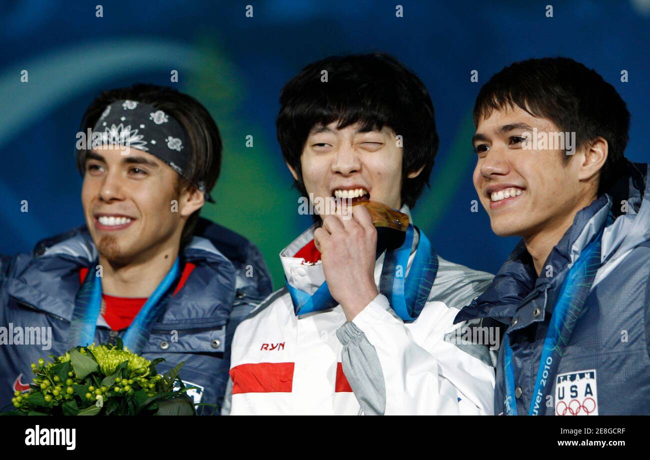 Gold medallist Lee Jung-su (C) of South Korea bites his medal beside silver medallist Apolo Anton Ohno (L) of the U.S. and bronze medallist J.R. Celski of the U.S. during the medal ceremony for the men's 1500 metres short track speed skating competition at the Vancouver 2010 Winter Olympics February 14, 2010. REUTERS/Andy Clark (CANADA) Stock Photo