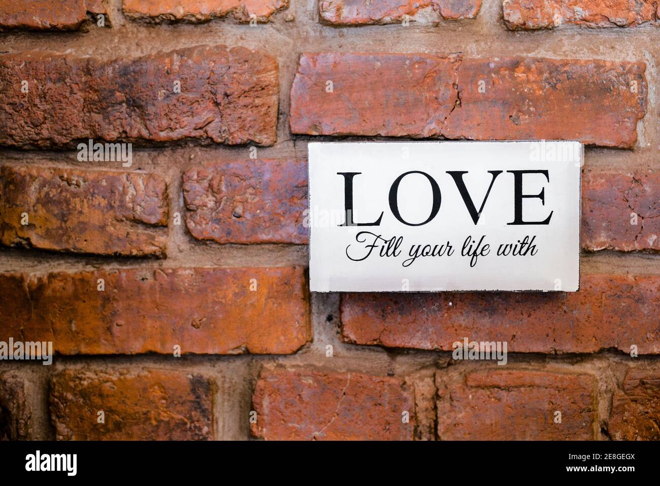 nameplate with love sign on the brick wall. Stock Photo