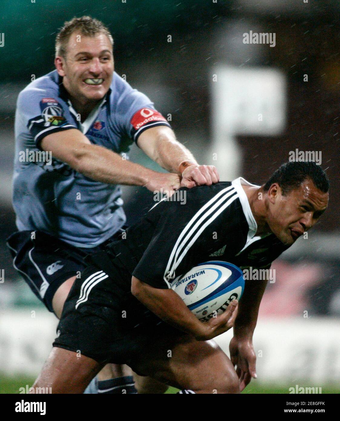 Pehi Te Whare of the New Zealand Maori (R) beats the tackle of Peter Hewat of the New South Wales Waratahs during their international rugby union match in Sydney June 2, 2006. REUTERS/Will Burgess (AUSTRALIA) Stock Photo
