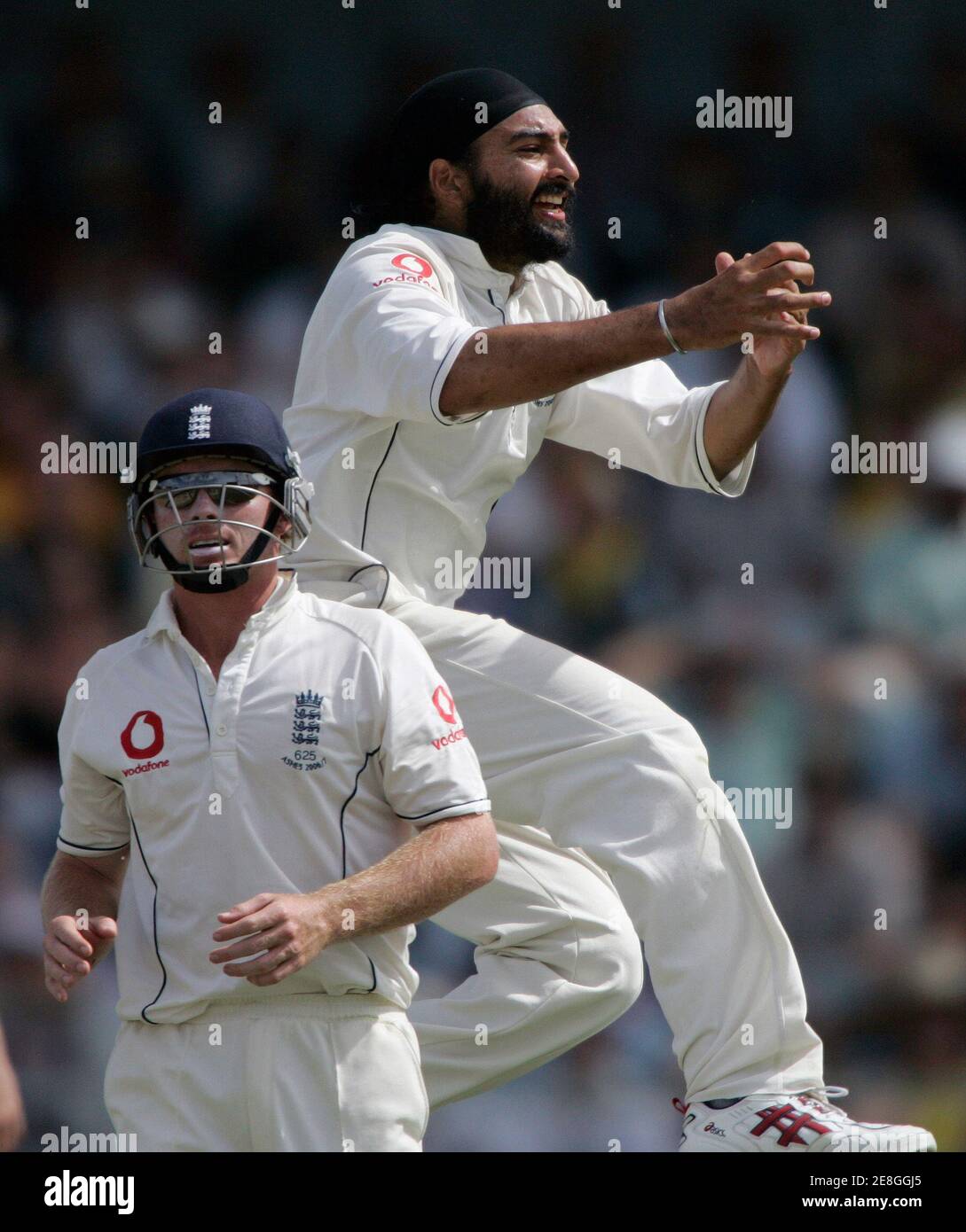 England's Monty Panesar (R) leaps into the air as team mate Ian Bell moves in after Panesar dismissed Australia's Michael Hussey during day three of the third Ashes cricket test in Perth December 16, 2006. MOBILES OUT, EDITORIAL USE ONLY REUTERS/Will Burgess  (AUSTRALIA) Stock Photo