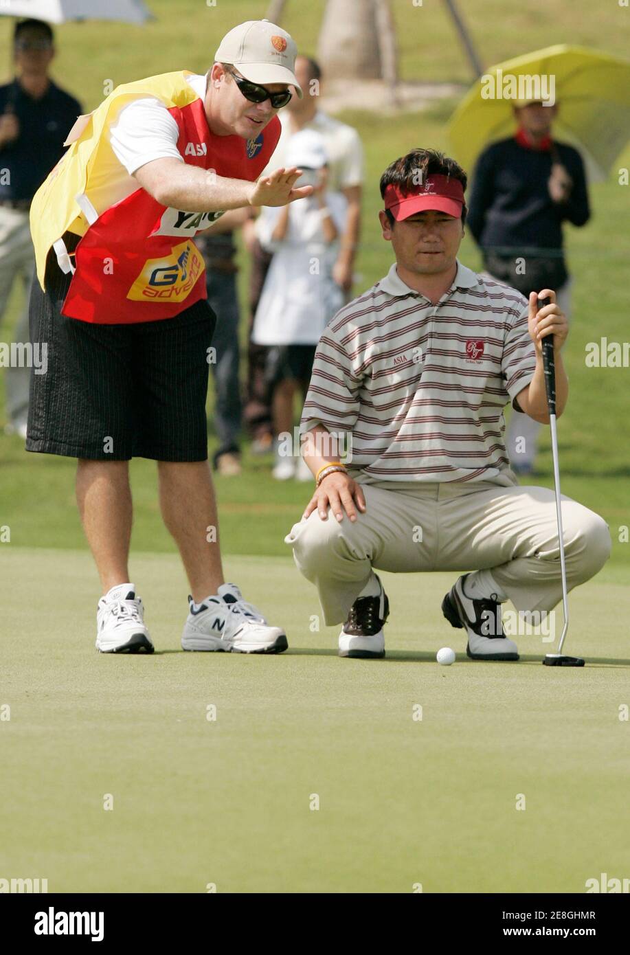 YE Yang (R) of South Korea lines up a putt on the 2nd hole during the four-ball match of the Royal Trophy Europe vs Asia Golf Championship at Amata Spring Country Club on the outskirts of Bangkok January 13, 2007. REUTERS/Chaiwat Subprasom (THAILAND) Stock Photo
