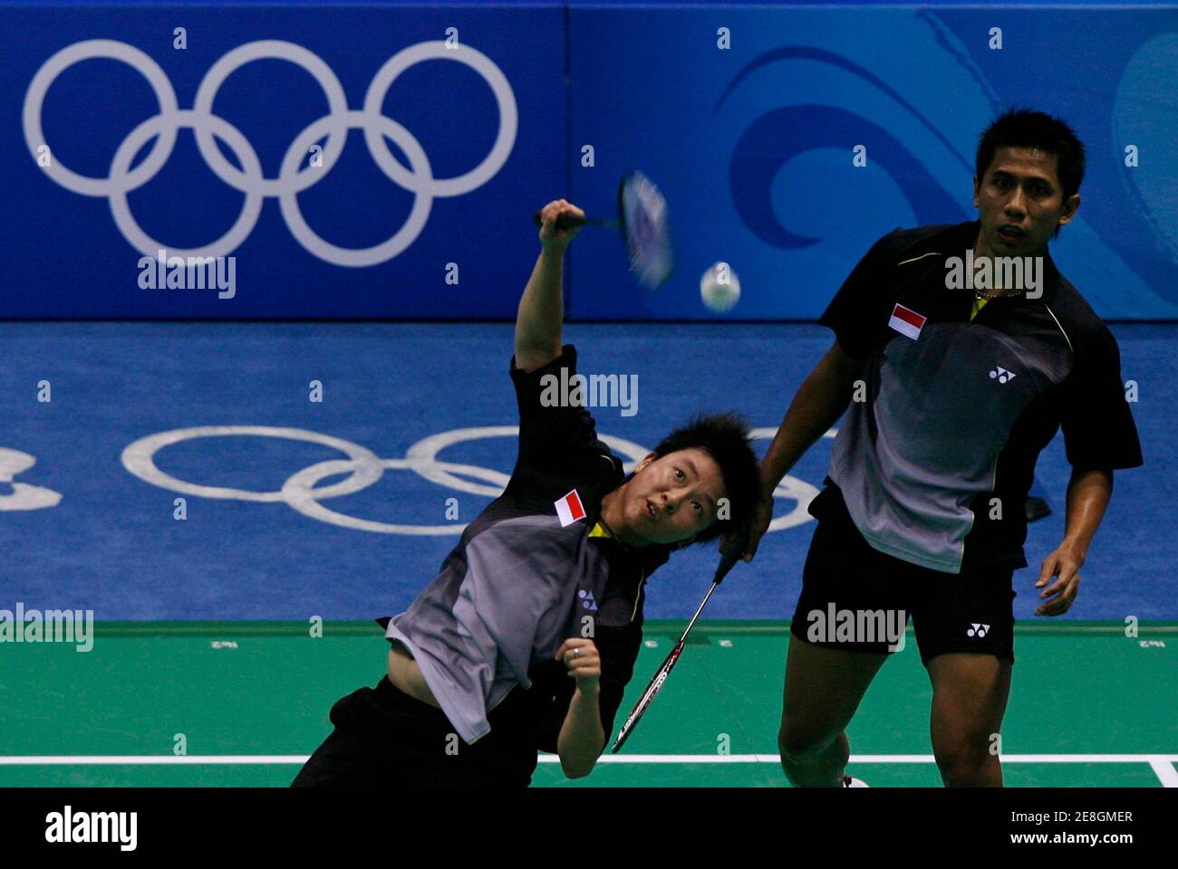 Nova Widianto of Indonesia (R) watches his teammate Liliyana hit a return to Han Sang-hun and Hwang Yu-mi of South Korea during their mixed doubles round of 16 badminton match at the Beijing 2008 Olympic Games, August 12, 2008.     REUTERS/Beawiharta (CHINA) Stock Photo