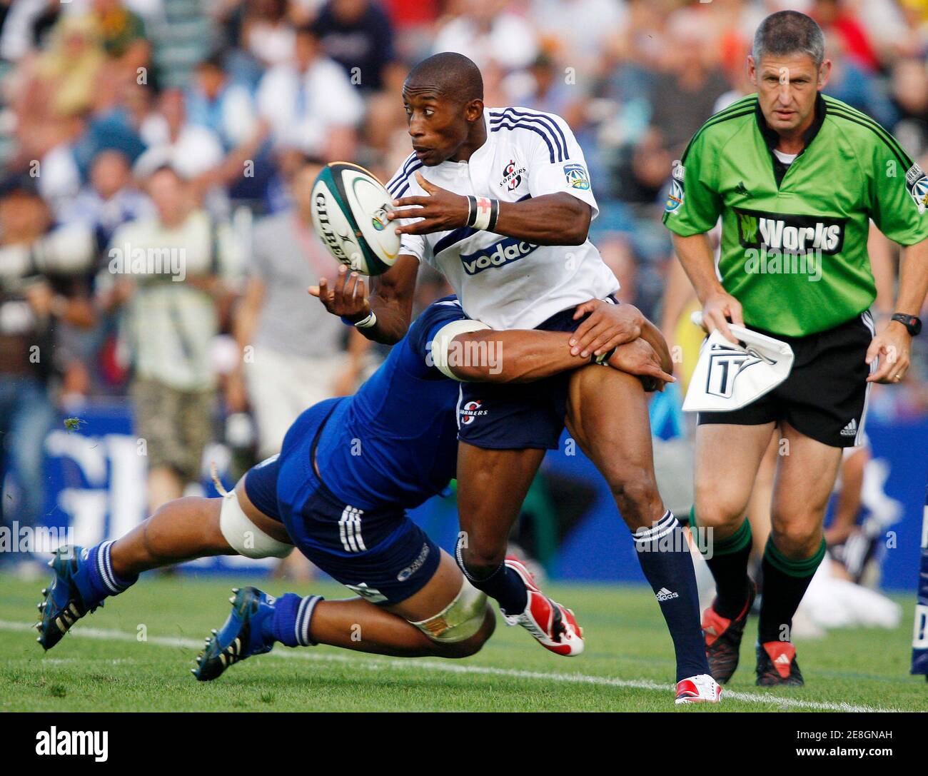 Tonderai Chavhanga (C) of the Stormers passes the ball as he is tackled by Nick  Williams (L) of the Blues during the Super 14 rugby match at Eden Park in  Auckland March