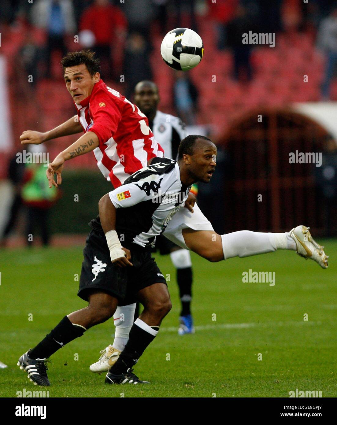 Red Star's Vladimir Bogdanovic (L) jumps for the ball with Partizan's Almani Moreira during their Serbia first division derby soccer match in Belgrade October 5, 2008. REUTERS/Ivan Milutinovic  (SERBIA) Stock Photo