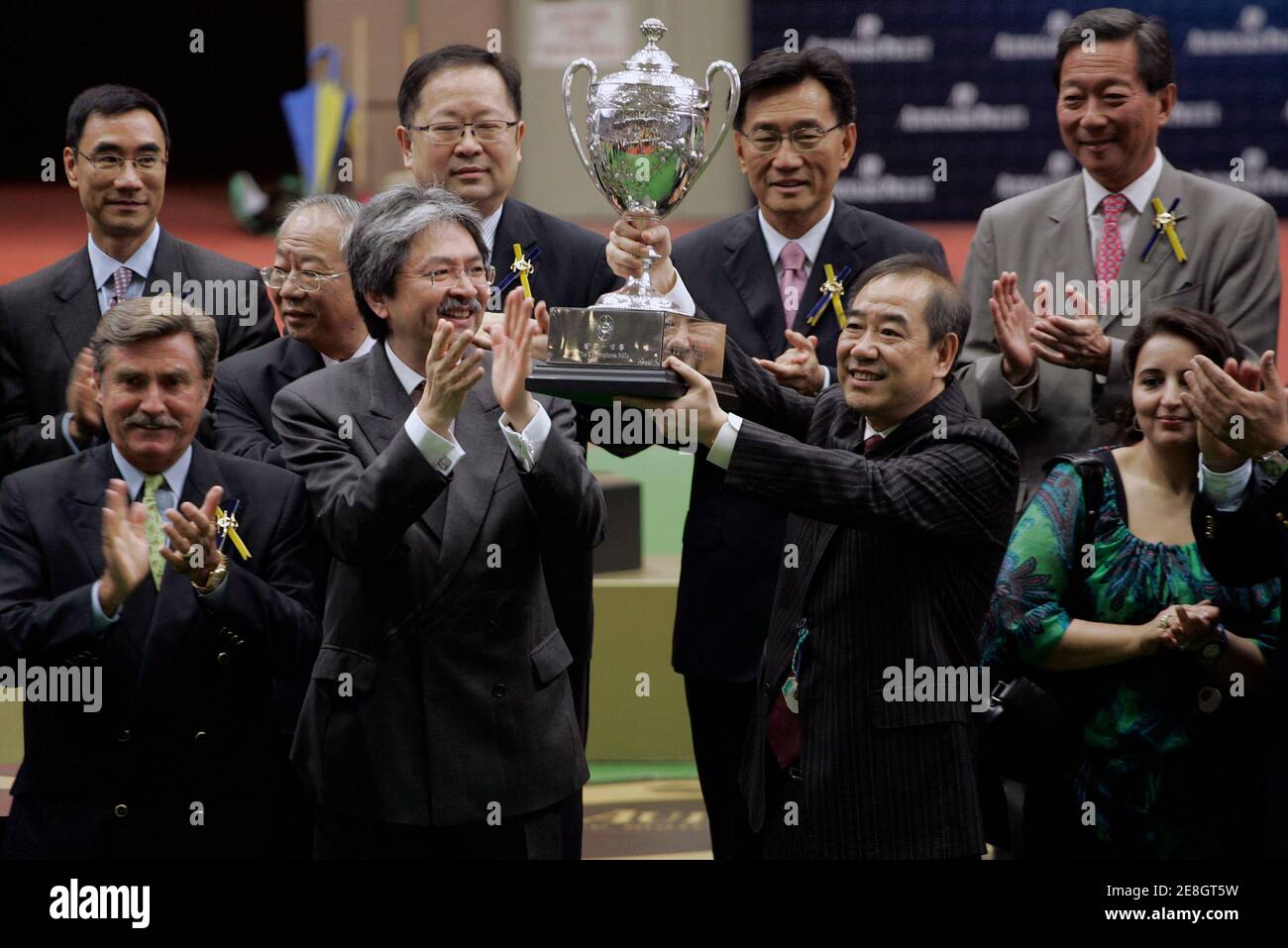 Horse owner Tam Wing-Kun holds the trophy next to Hong Kong's Financial Secretary John Tsang after Sight Winner won the Champions Mile horse race at Shatin racecourse in Hong Kong April 26, 2009.     REUTERS/Tyrone Siu    (CHINA SPORT EQUESTRIANISM) Stock Photo