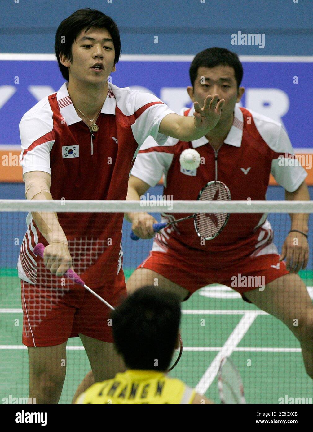 South Korea's Lee Yong-dae (front) serves as his teammate Jung Jae-sung watches during their men's doubles semi-final match against China's Zhang Nan and Chai Biao at the Victor Korea Open Badminton Super Series in Seoul January 16, 2010.  REUTERS/Jo Yong-Hak (SOUTH KOREA - Tags: SPORT BADMINTON) Stock Photo