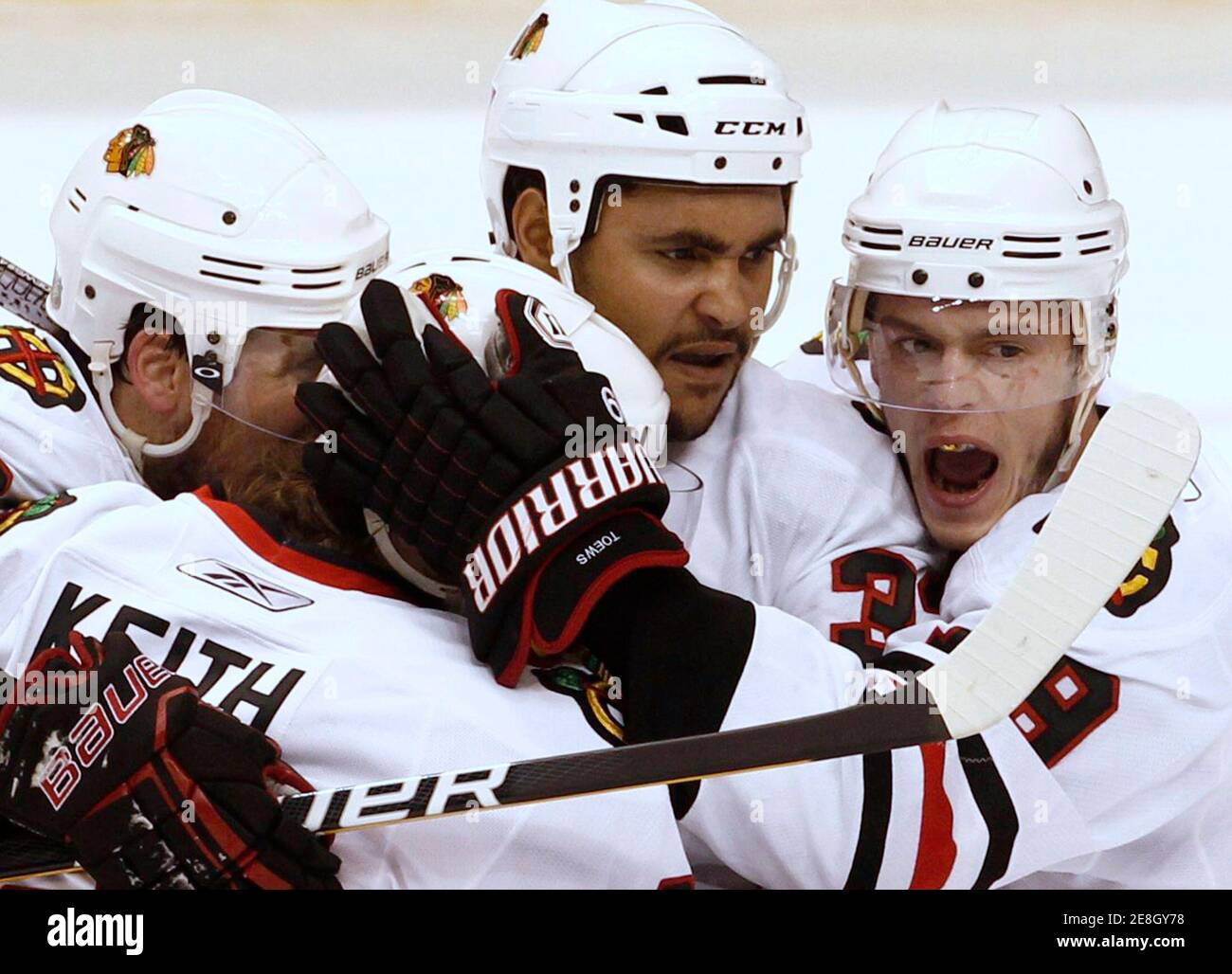 Chicago Blackhawks right wing Dustin Byfuglien (C) is congratulated by teammates Jonathan Toews (R) ,Duncan Keith (L2) and Patrick Sharp (L) after scoring against the Vancouver Canucks in the first period during Game 3 of their NHL Western Conference semi-final hockey game in Vancouver, British Columbia May 5, 2010.     REUTERS/Andy Clark       (CANADA - Tags: SPORT ICE HOCKEY) Stock Photo