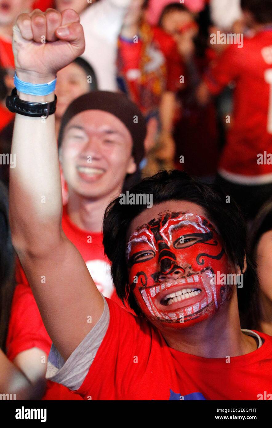 A South Korean soccer fan reacts as he watches a live TV broadcast of their 2010 World Cup Group B soccer match against Nigeria in Durban, at the Seoul City Hall Plaza June 23, 2010. South Korea drew 2-2 in a tense match with Nigeria to advance to the second round of the World Cup on Tuesday.  REUTERS/Jo Yong-Hak (SOUTH KOREA - Tags: SPORT SOCCER WORLD CUP) Stock Photo