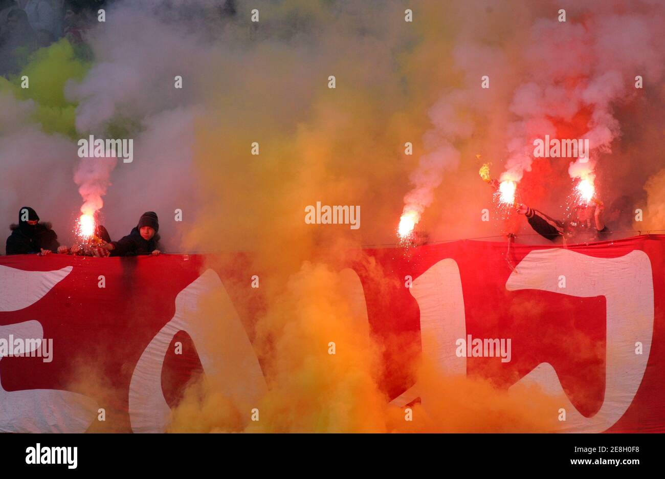 Red Star Belgrade soccer fans light flares during the Serbia and Montenegro first division derby match against Zeta in Belgrade December 4, 2005. REUTERS/Ivan Milutinovic Stock Photo