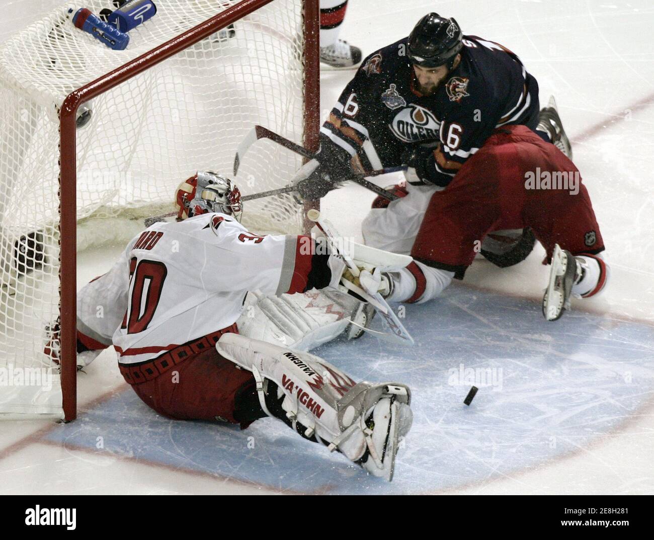 Carolina Hurricanes goalie Cam Ward (L) makes a save as Edmonton Oilers' Jarret Stoll (C) holds down Carolina Hurricanes' Matt Cullen during the second period of Game 3 in their Stanley Cup Finals ice hockey game in Edmonton, Alberta June 10, 2006. Stoll was given a holding penalty on the play. REUTERS/Andy Clark (CANADA) Stock Photo