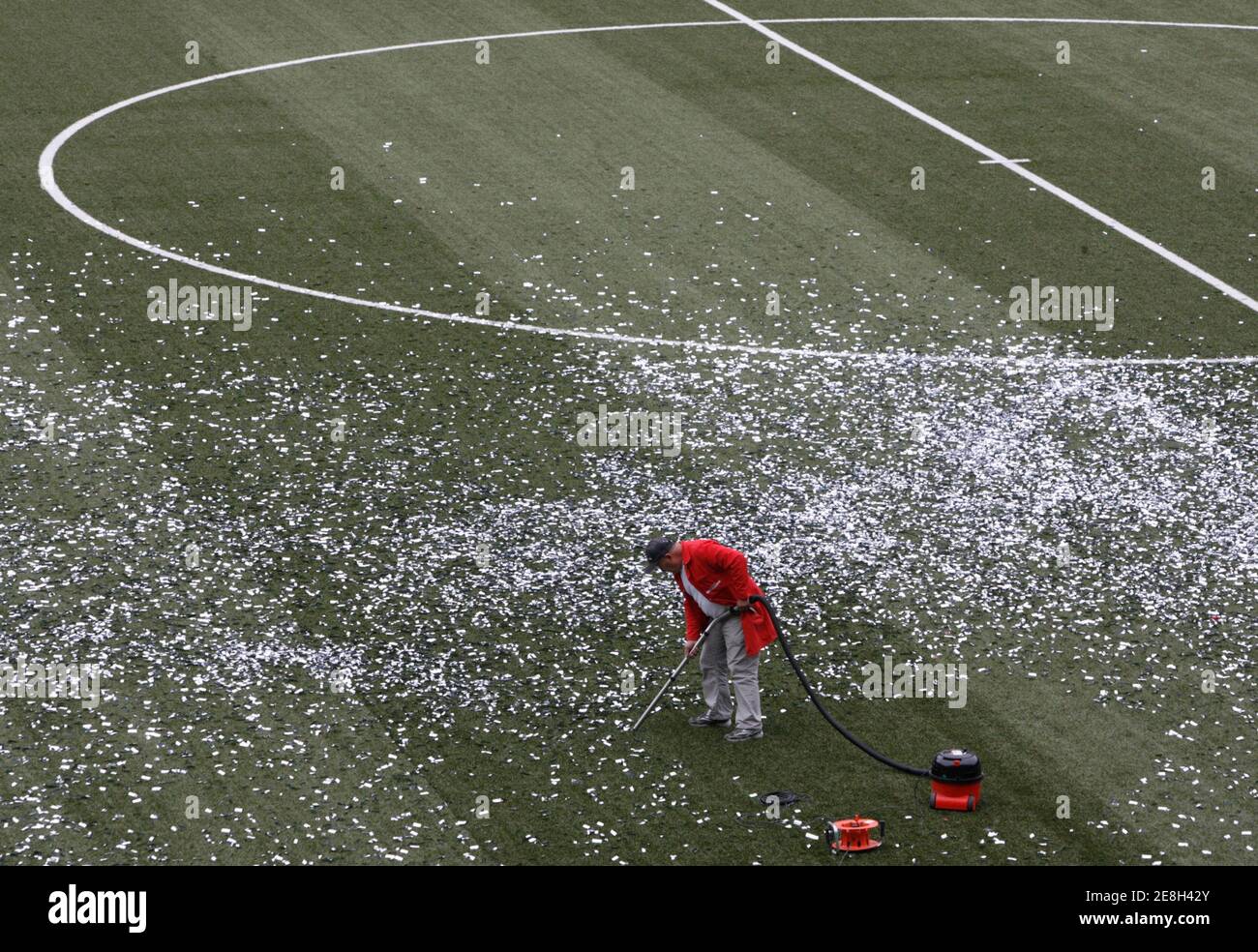 A worker cleans up confetti from the pitch with a vacuum cleaner after the Swiss cup final soccer match between  FC Luzern and FC Basel's (FCB) at the Stade de Suisse in Bern May 28, 2007.   FC Basel's (FCB) won the Swiss cup. REUTERS/Pascal Lauener (SWITZERLAND) Stock Photo