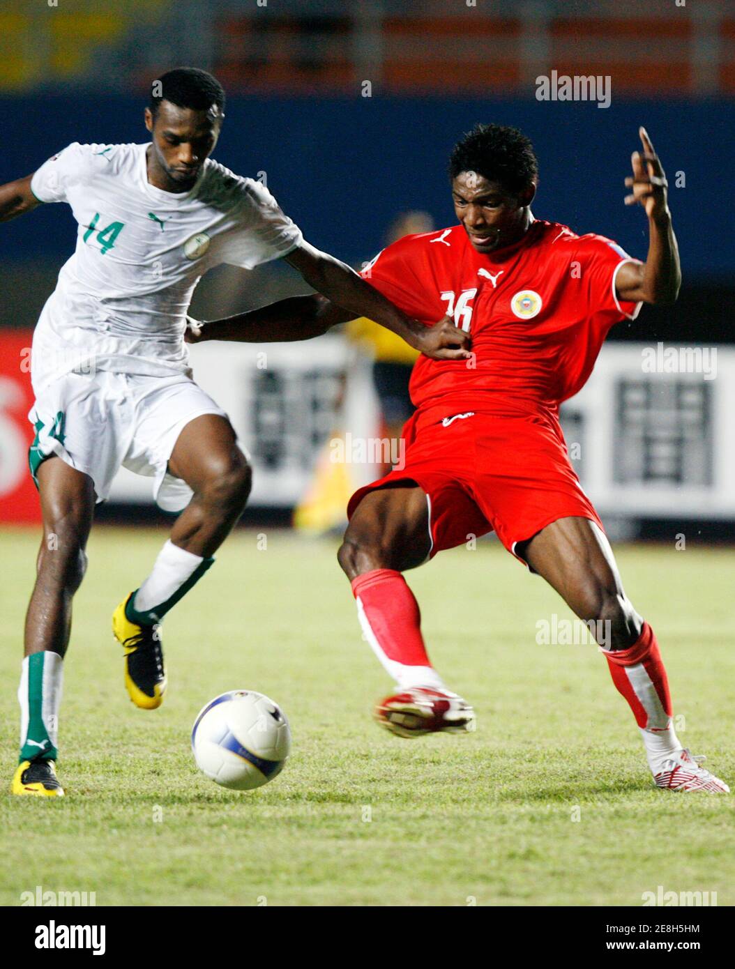 Saudi Arabia's Saud Khariri (L) fights for the ball with Bahrain's Jaycee John Akwani during their 2007 AFC Asian Cup soccer tournament Group D match in the Indonesian city of Palembang July 18, 2007. REUTERS/Beawiharta (INDONESIA) Stock Photo