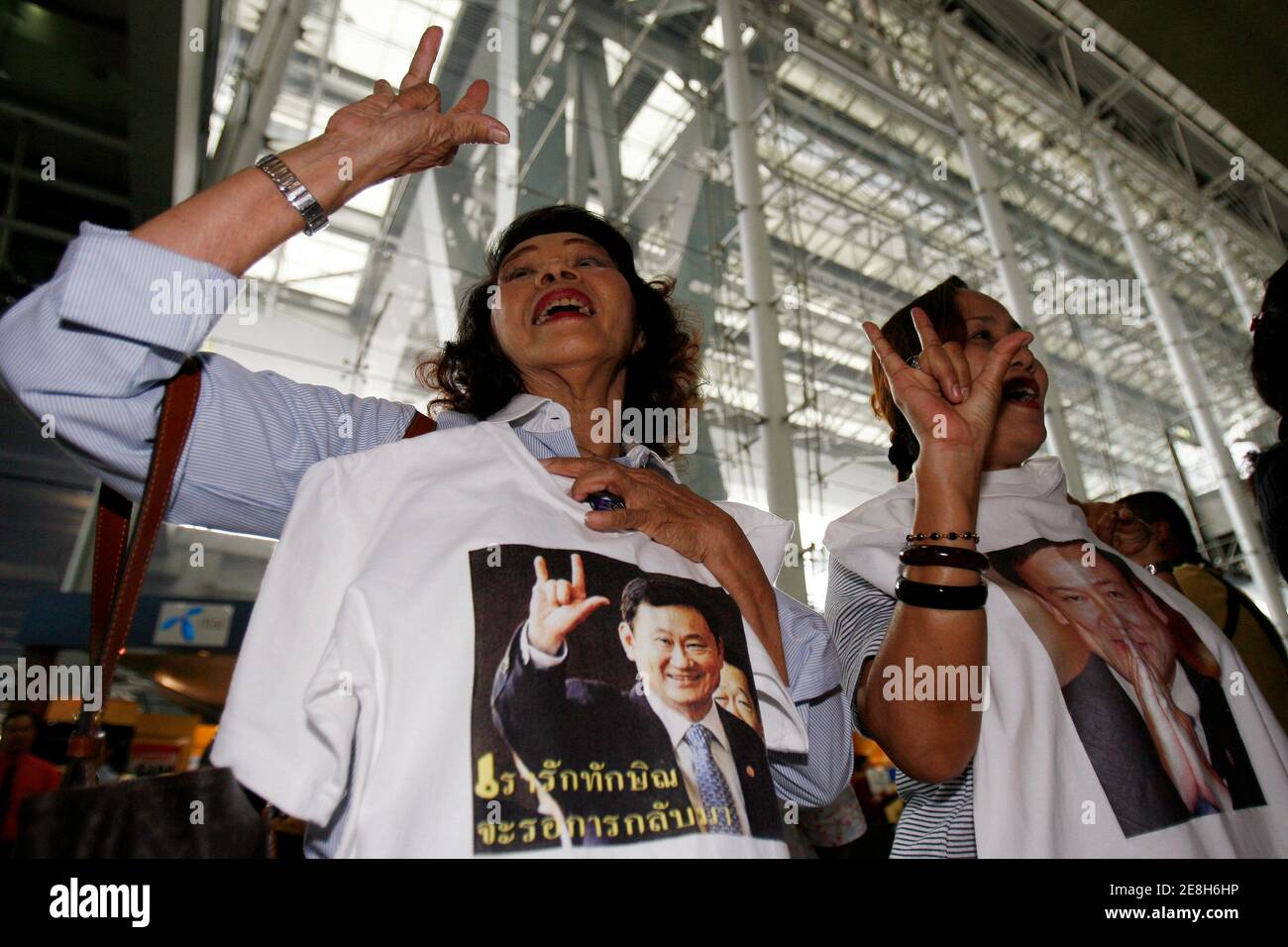 Supporters of former Prime Minister Thaksin Shinawatra hold T-shirts of Thaksin as they wait for Manchester City manager Sven Goran-Eriksson and midfielder Sun Jihai to arrive at Suvarnabhumi international airport in Bangkok November 15, 2007. Manchester City coach Sven-Goran Eriksson arrived in Bangkok on Thursday to raise the team's profile in Asia, but there were fewer club fans to greet him than security guards and supporters of owner Thaksin Shinawatra. REUTERS/Chaiwat Subprasom (THAILAND) Stock Photo