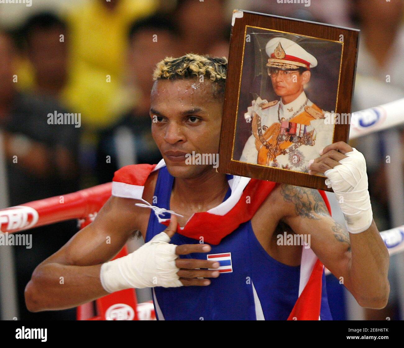 Thailand's Amnat Ruenroeng celebrates as he holds a portrait of Thailand's King Bhumibol Adulyadej after his win over Malaysia's Zamzai Azizi Mohamad during the Men's Lt. flyweight 48kg boxing final at the SEA Games in Nakhon Ratchasima December 13, 2007. Amnat won to take the gold.   REUTERS/Chaiwat Subprasom (THAILAND) Stock Photo