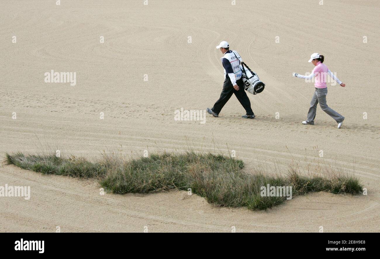 Kim In-kyung (R) of South Korea crosses a sand bunker with her caddie at the 8th hole during the final round of the LPGA Hana Bank-Kolon Championship golf tournament at Sky72 Golf Club Ocean course in Incheon, west of Seoul, November 2, 2008. Hull finished the golf tournament with a course record 5 under par as the second rank.  REUTERS/Jo Yong-Hak (SOUTH KOREA) Stock Photo