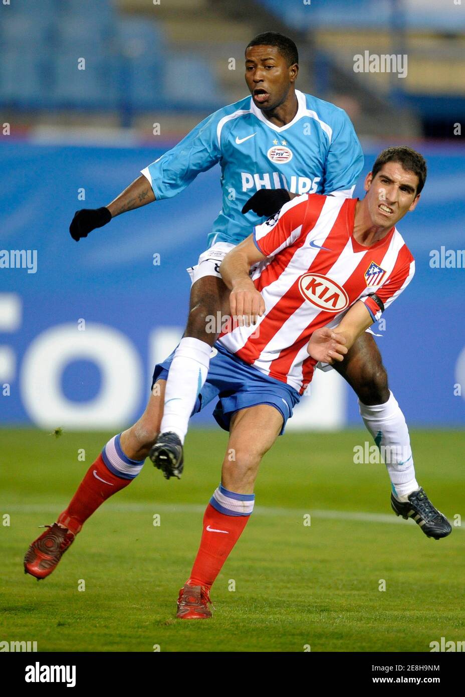 PSV Eindhoven's Edison Mendez falls over Atletico Madrid's Raul Garcia (R)  during their Champions League soccer match at Vicente Calderon stadium in  Madrid, November 26, 2008. UEFA has ordered the Group D