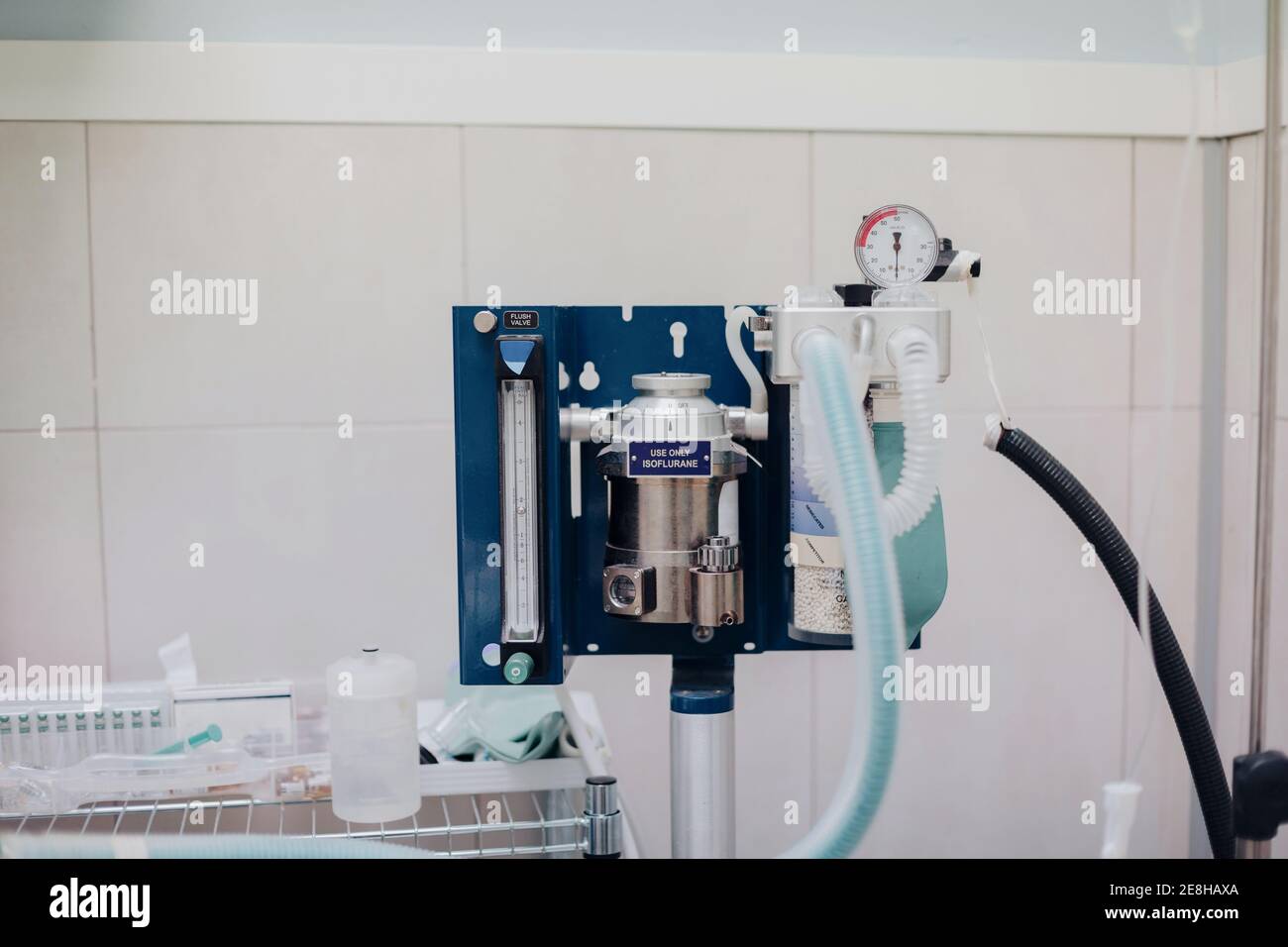 Anesthesia machine with ribbed plastic hoses near metal canister and