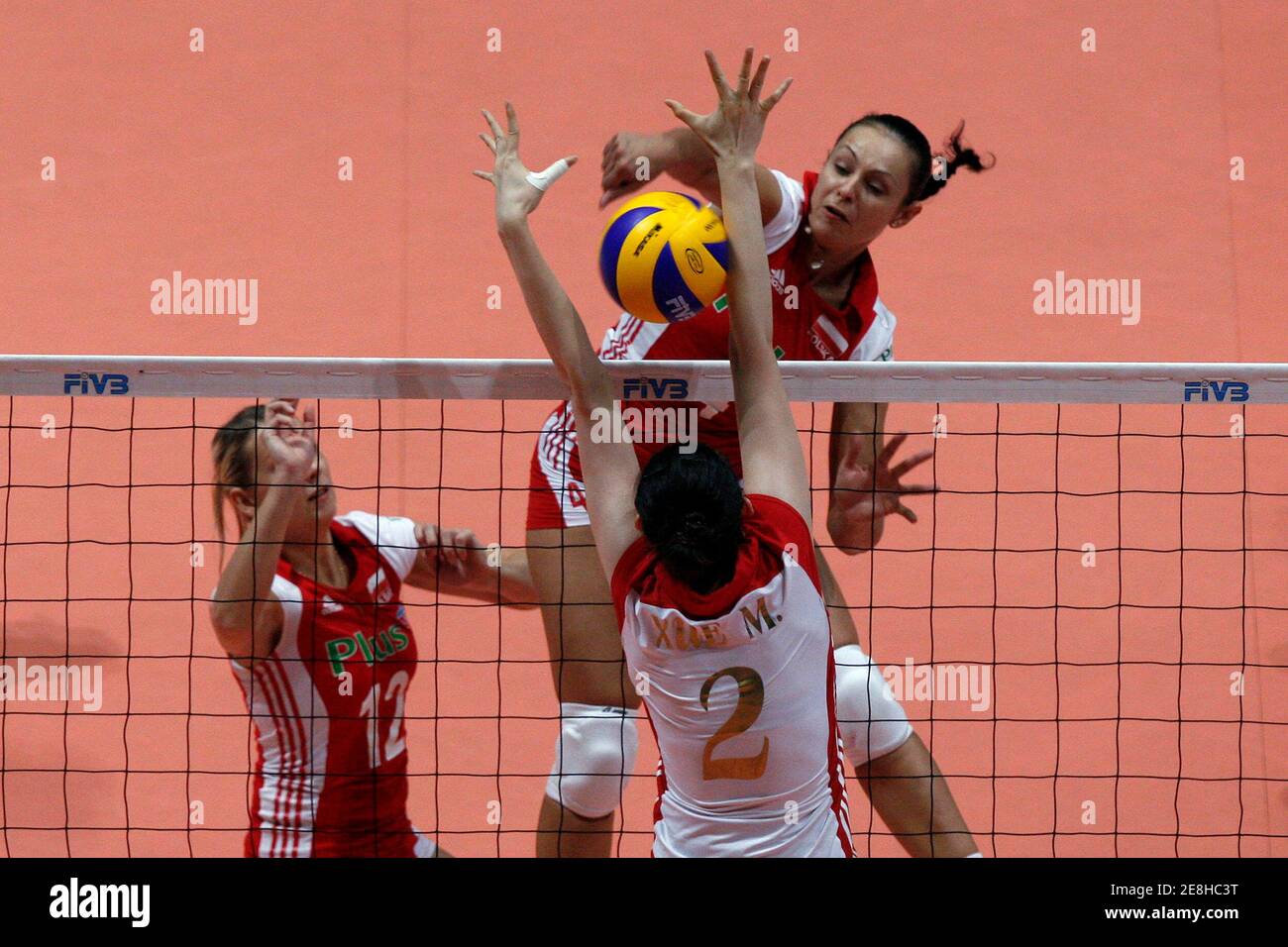 Dorota Pykosz (top R) and Milena Sadurek Mikolajczyk (top L) of Poland spike the ball against Xue Ming of China during their FIVB World Grand Prix women's volleyball tournament in Hong Kong August 15, 2009. REUTERS/Tyrone Siu    (CHINA SPORT VOLLEYBALL) Stock Photo
