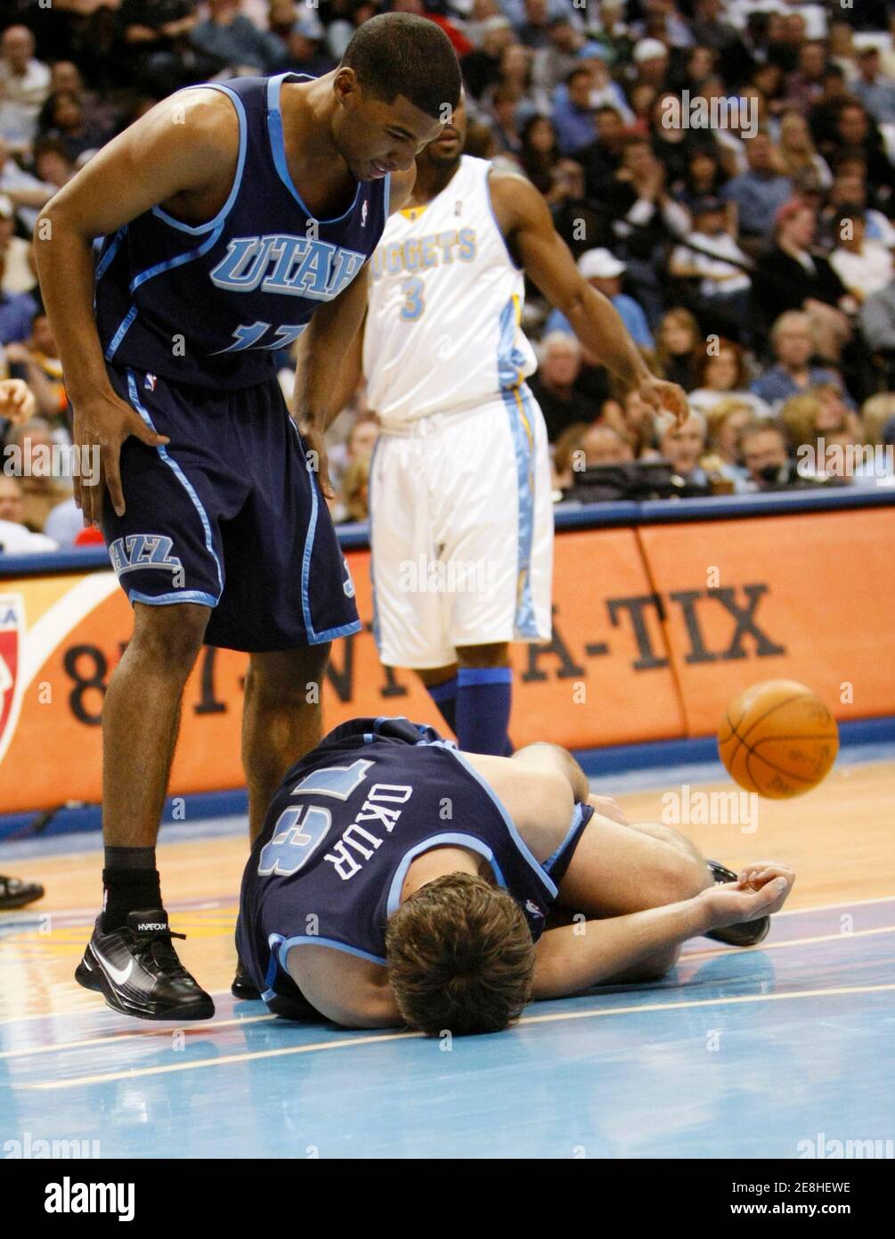 Utah Jazz Ronnie Price (L) looks at starting center Mehmet Okur as he lies on the court injured in Game 1 of their NBA Western Conference playoff series against the Denver Nuggets in Denver April 17, 2010. REUTERS/Rick Wilking (UNITED STATES - Tags: SPORT BASKETBALL) Stock Photo
