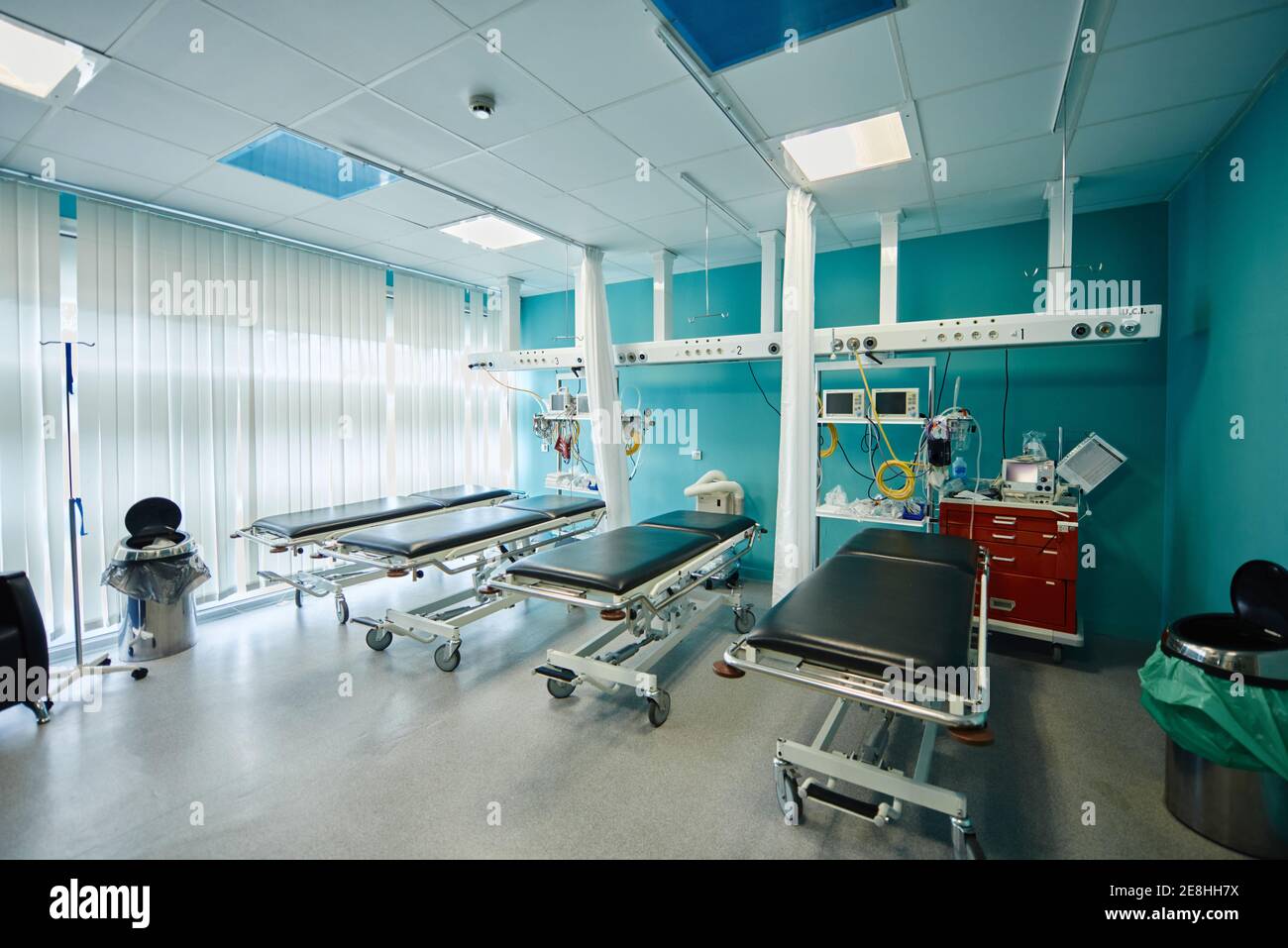Interior of spacious treatment room with medical couches and monitors
