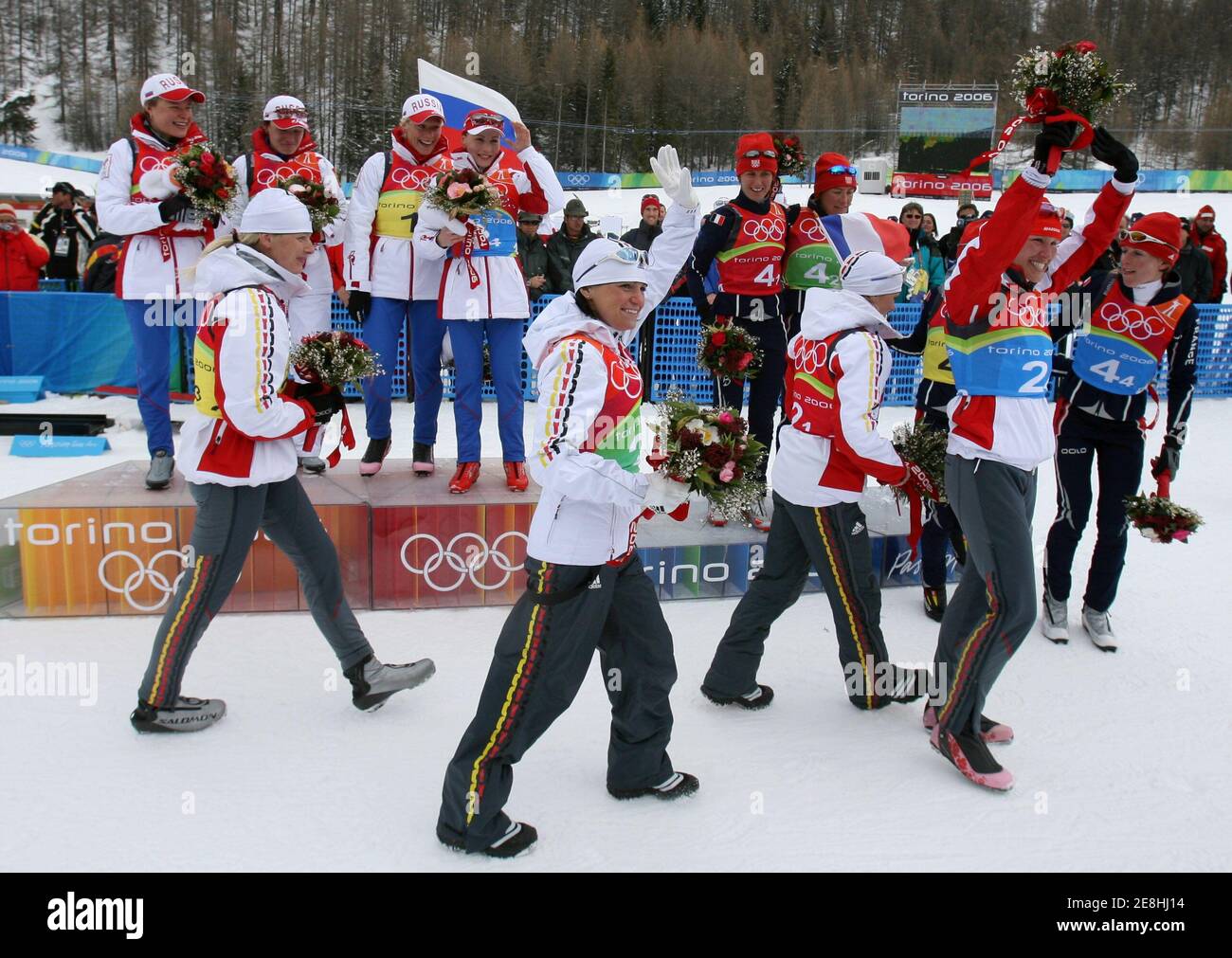 Andrea Henkel (C) of Germany waves to spectators as she leaves the podium with fellow silver medallist team members after the women's 4x6 km biathlon relay event at the Torino 2006 Winter Olympic Games in San Sicario, Italy, February 23, 2006.   REUTERS/Pascal Lauener Stock Photo