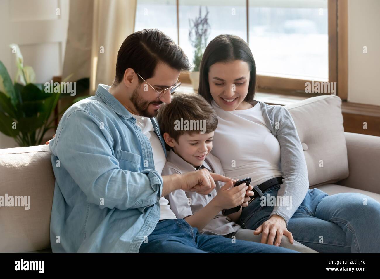 Happy parents with small son use smartphone Stock Photo Alamy