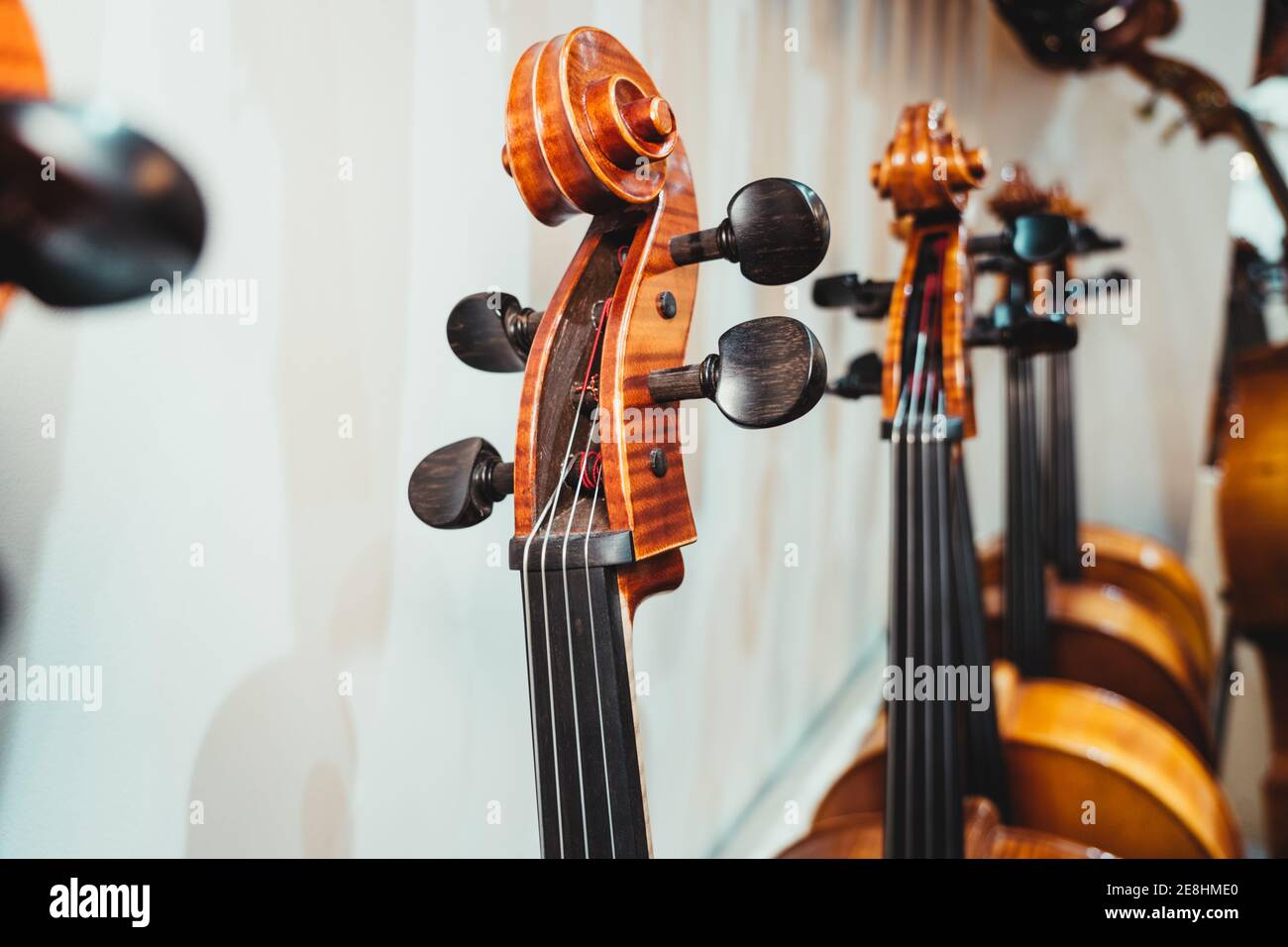 Modern violin curvy scroll with pegs against collection of acoustic ...