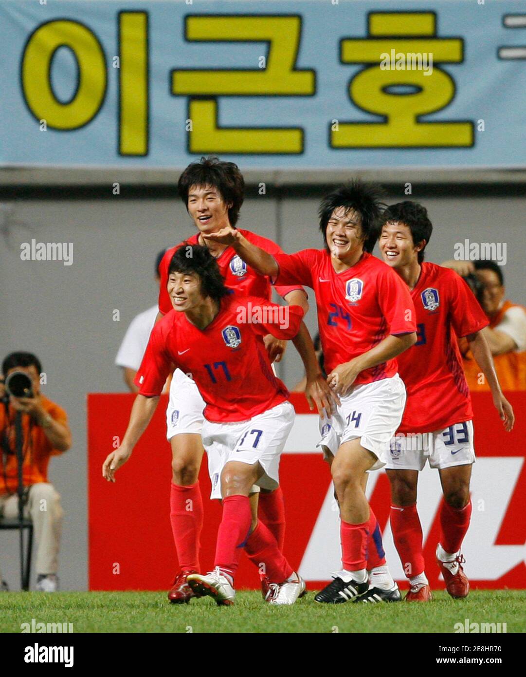 South Korea's Lee Keun-ho (17) celebrates with his teammates after scoring a goal against Uzbekistan during the final Asian qualifying round for soccer in the 2008 Beijing Olympic Games, at the World Cup stadium in Seoul, August 22, 2007. The banner in the background reads: 'Lee Keun-ho'.  REUTERS/Jo Yong-Hak (SOUTH KOREA) Stock Photo