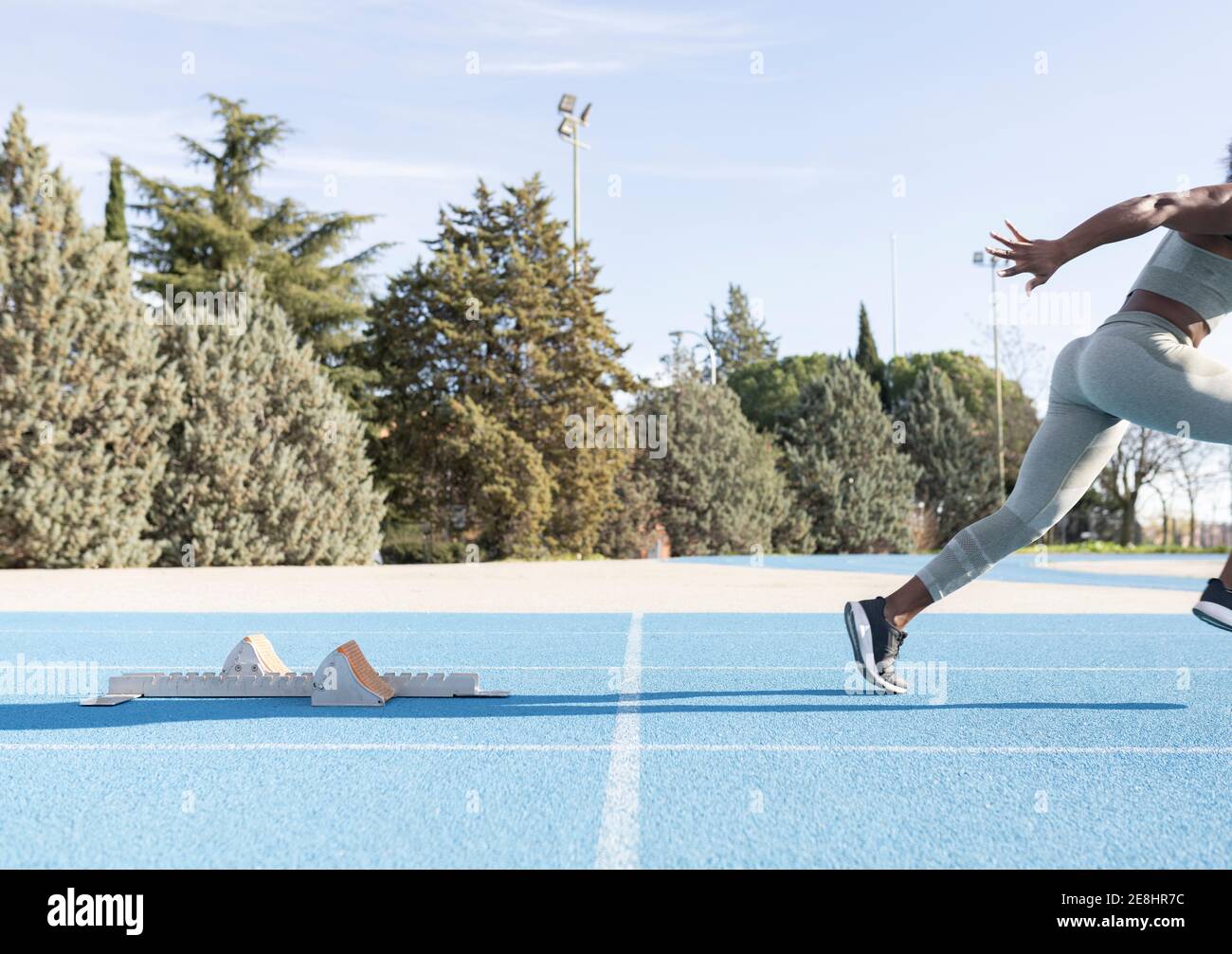 Side view of energetic African American female athlete running out of
