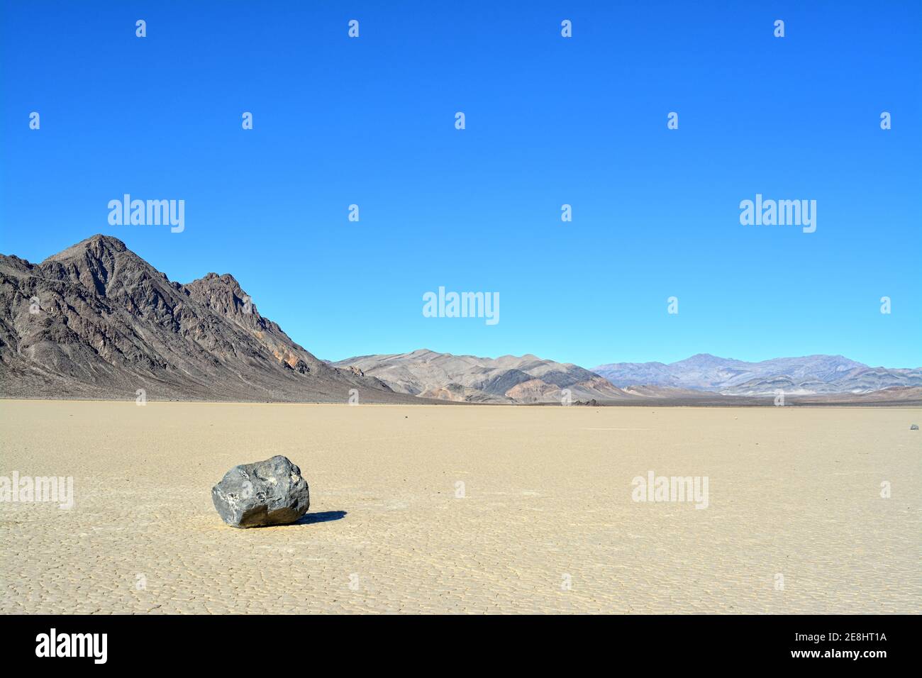 sailing rock leaving a long trail in the desert of the Racetrack Playa marks the path of one of the mysterious moving rocks in the Death Valley Nation Stock Photo