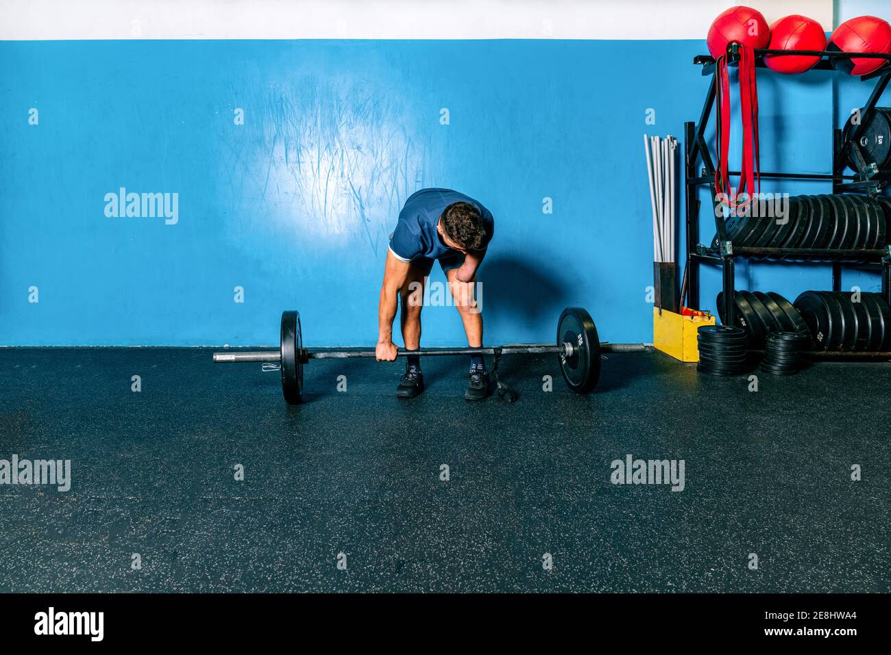 Powerful male athlete without hand lifting heavy weight during