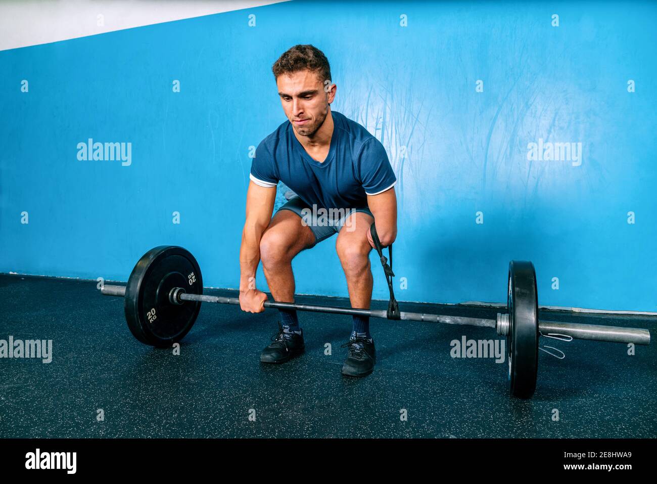 Powerful male athlete without hand lifting heavy weight during