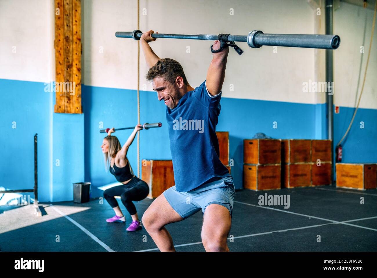 Powerful sportsWoman with handicapped male athlete lifting heavy weights and looking forward