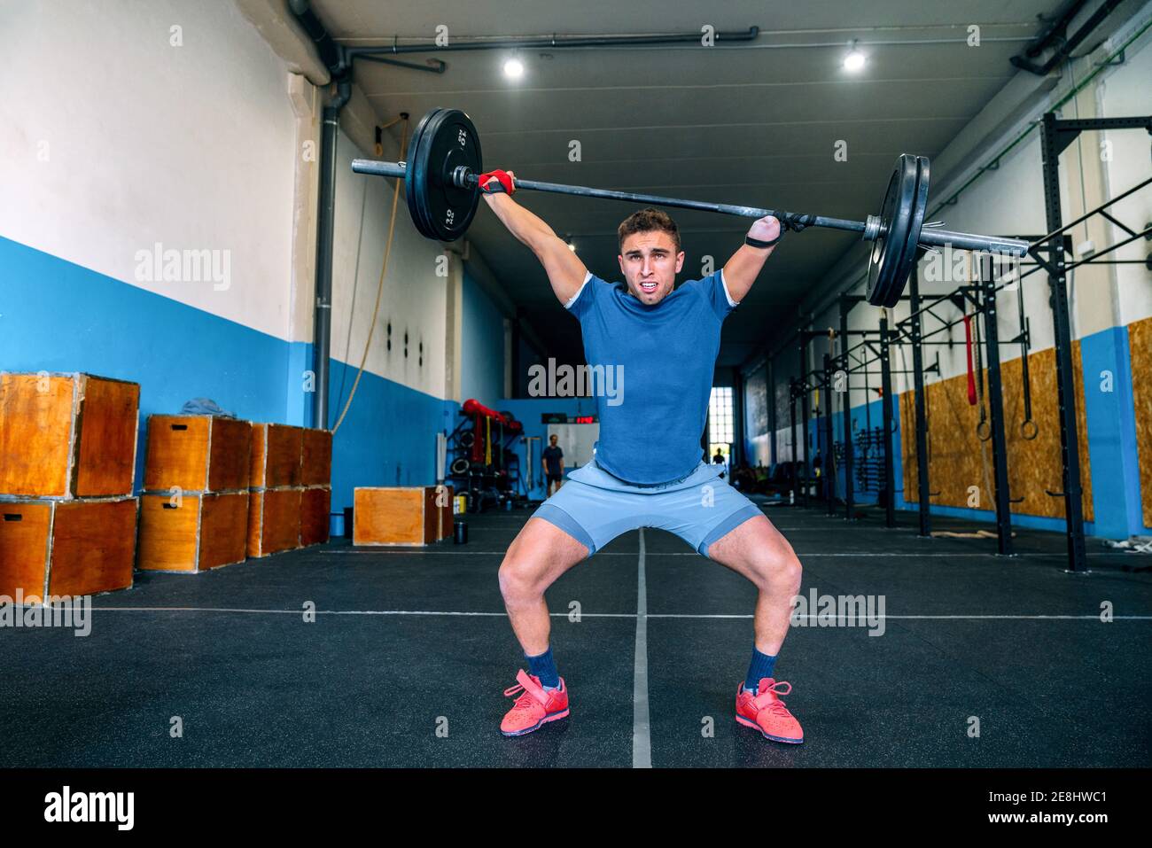 Powerful male athlete without hand lifting heavy weight during