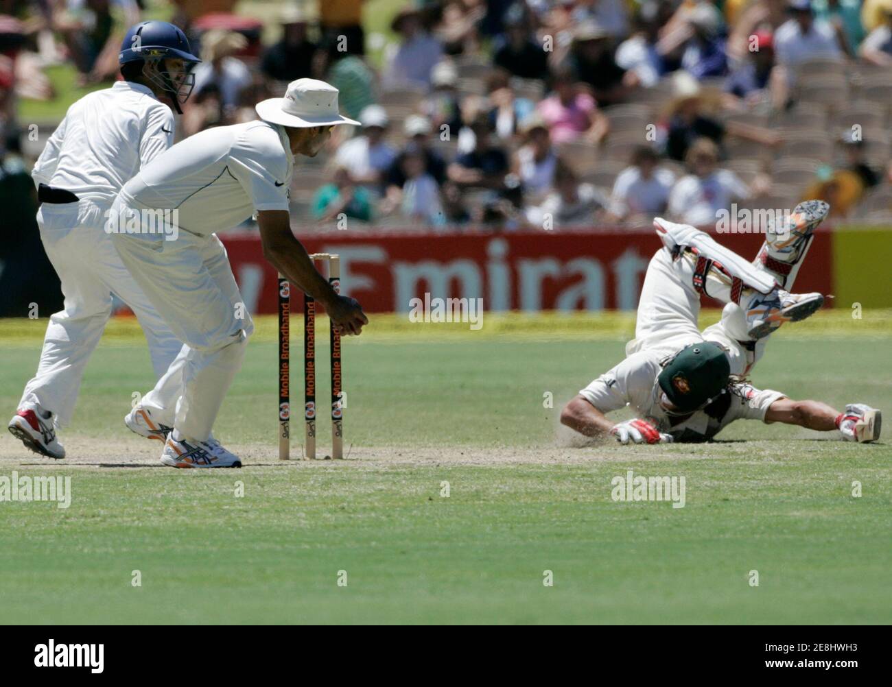Australia's Andrew Symonds (R) dives for the crease as India's Mahendra Dhoni (L) and VVS Laxman (2nd L) combine to field during the fourth day of their fourth and final test cricket match at the Adelaide Oval January 27, 2008. REUTERS/Will Burgess   (AUSTRALIA) Stock Photo