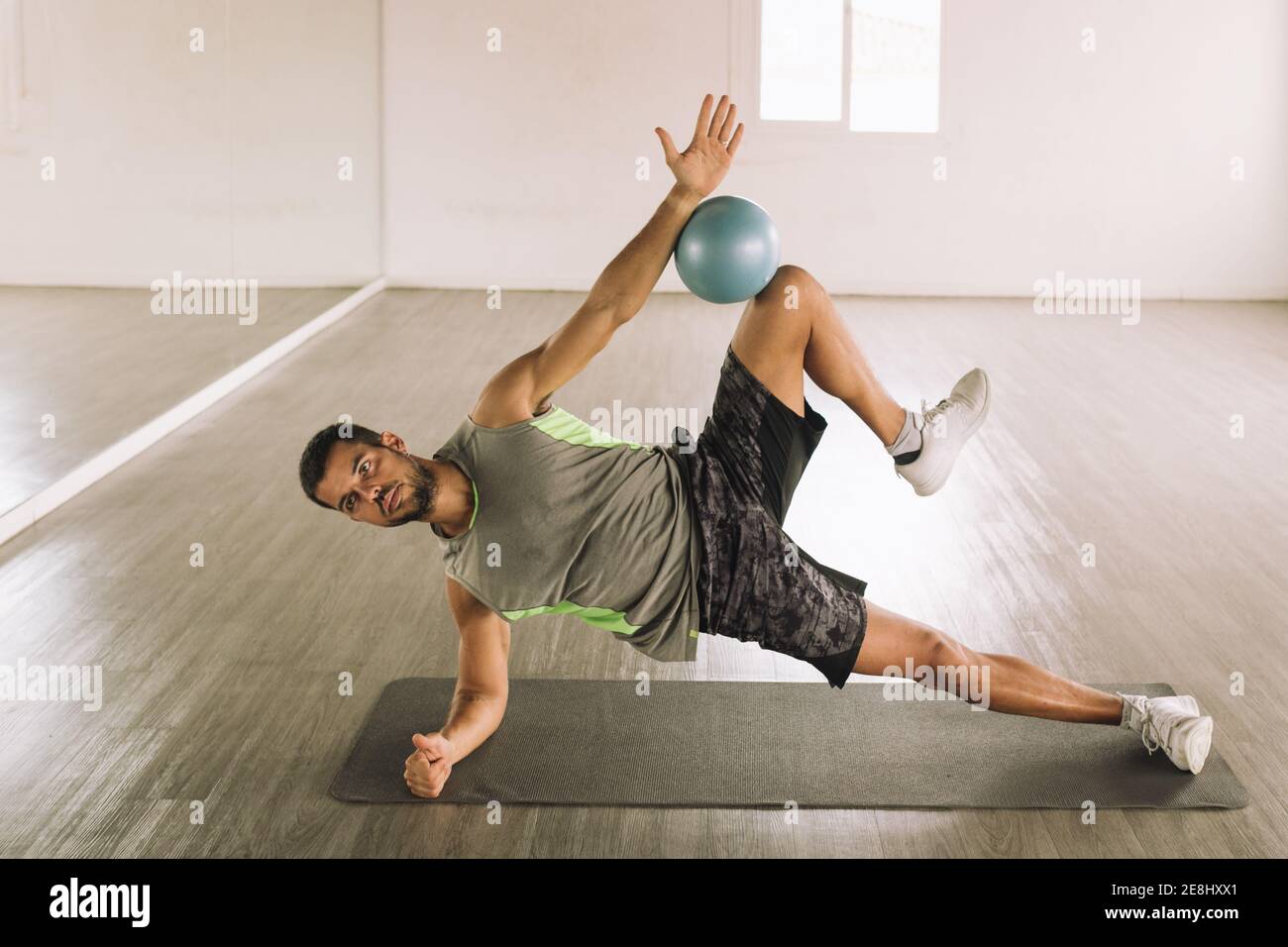 Side view of determined muscular young sportsman in activewear doing