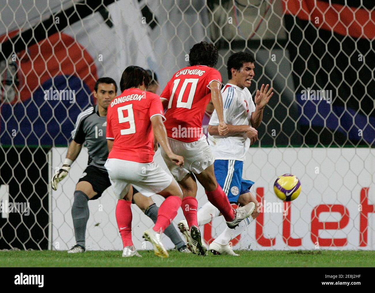 South Korea's Park Chu-Young (10) kicks to score a goal beside his teammate Cho Dong-gun (9) as Paraguay's Marcos Caceres (1st R) tries to block during their friendly soccer match at the Seoul World Cup stadium August 12, 2009.  REUTERS/Jo Yong-Hak (SOUTH KOREA SPORT SOCCER) Stock Photo
