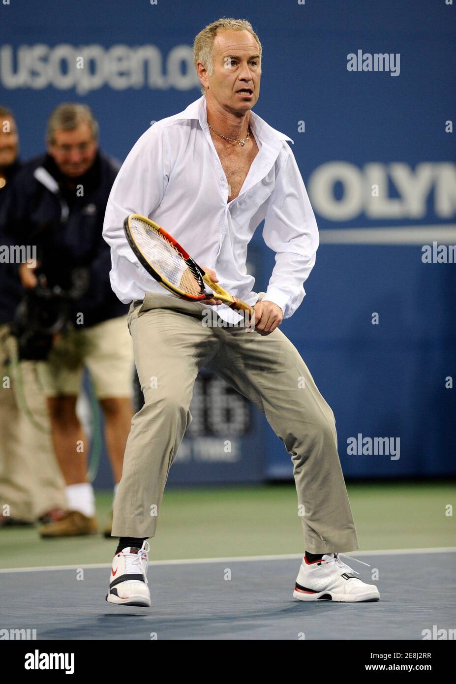 Former player and now tennis announcer John McEnroe comes down from the  announcers booth to play against Novak Djokovic of Serbia after Djokovic  invited him down on center court following his straight