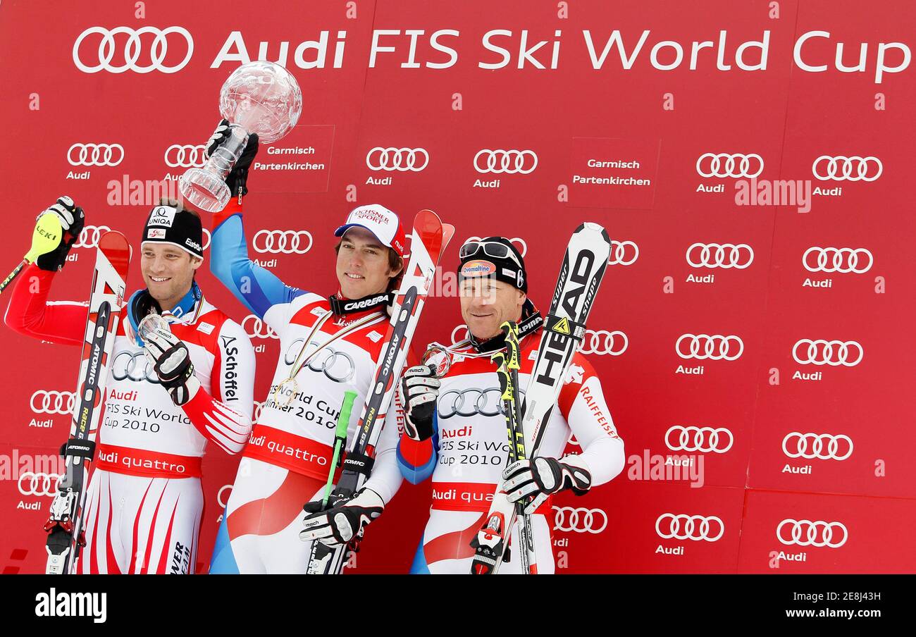 Carlo Janka (C) of Switzerland is flanked by Austria's second placed Benjamin Raich (L) and Switzerland's third placed Didier Cuche (R) after winning the men's overall Alpine Skiing World Cup trophy at the season's finals in Garmisch-Partenkirchen March 13, 2010.    REUTERS/Miro Kuzmanovic (GERMANY - Tags: SPORT SKIING) Stock Photo