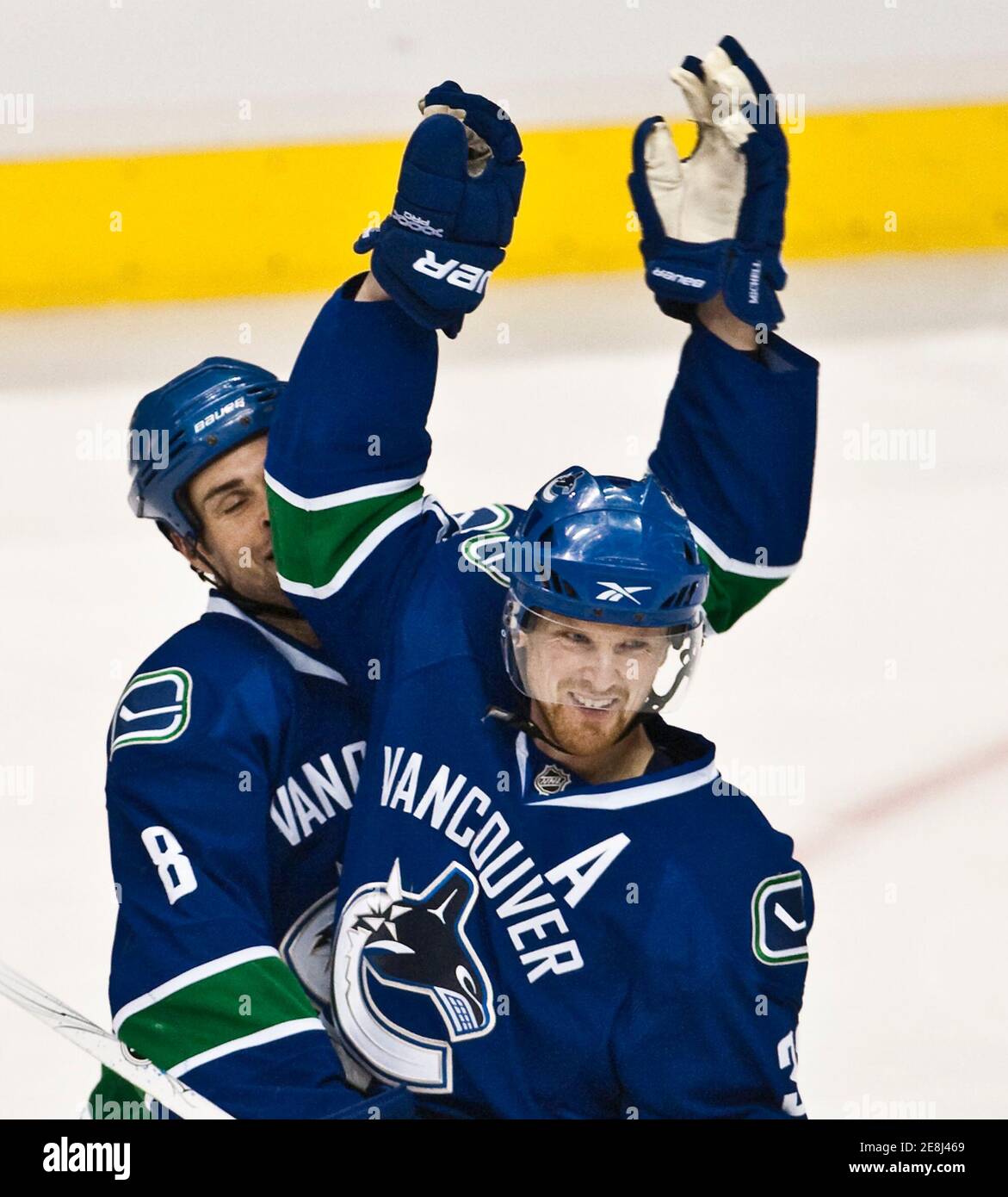 Vancouver Canucks Henrik Sedin (R) catches team mate Willie Mitchell in the face while celebrating his goal against the Columbus Blue Jackets during the second period of their NHL hockey game in Vancouver, British Columbia, January 5, 2010.         REUTERS/Andy Clark     (CANADA - Tags: SPORT ICE HOCKEY) Stock Photo