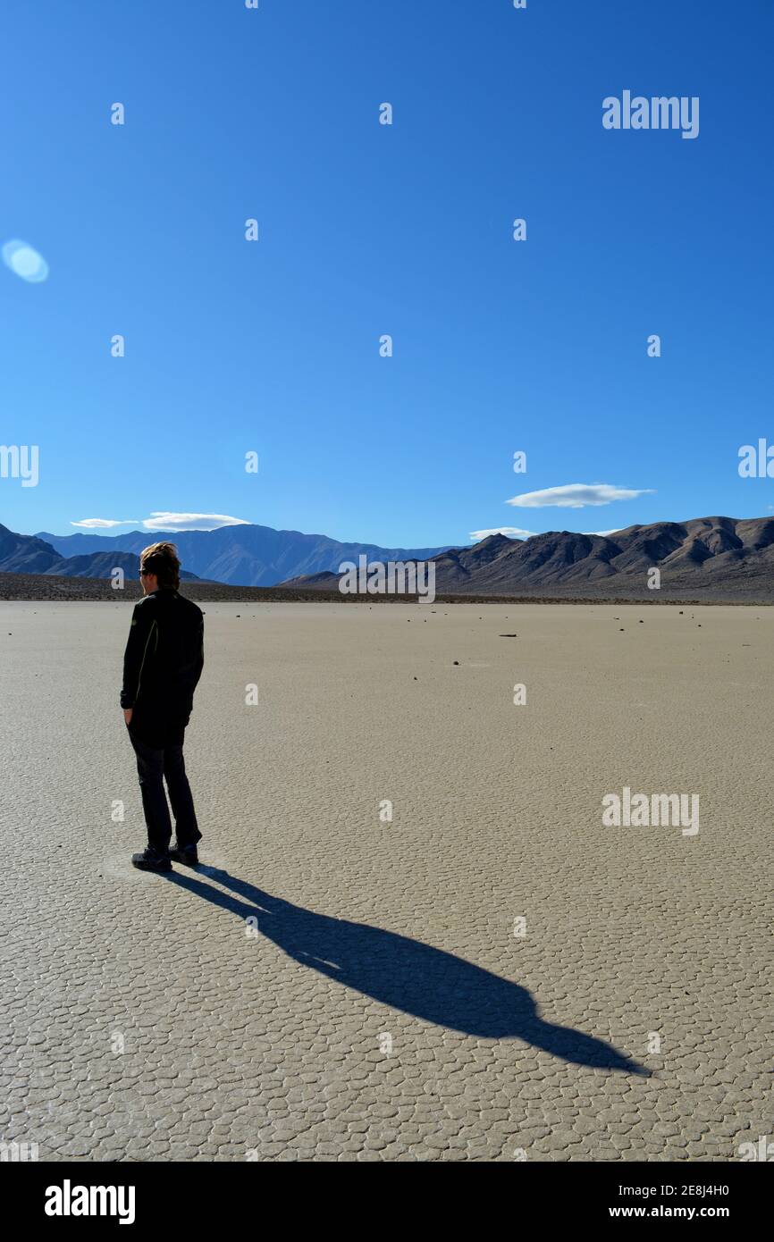 single person standing on the Racetrack Playa in the Death Valley National Park - one man exploration the sailing stones, a phenomenon in the desert, Stock Photo